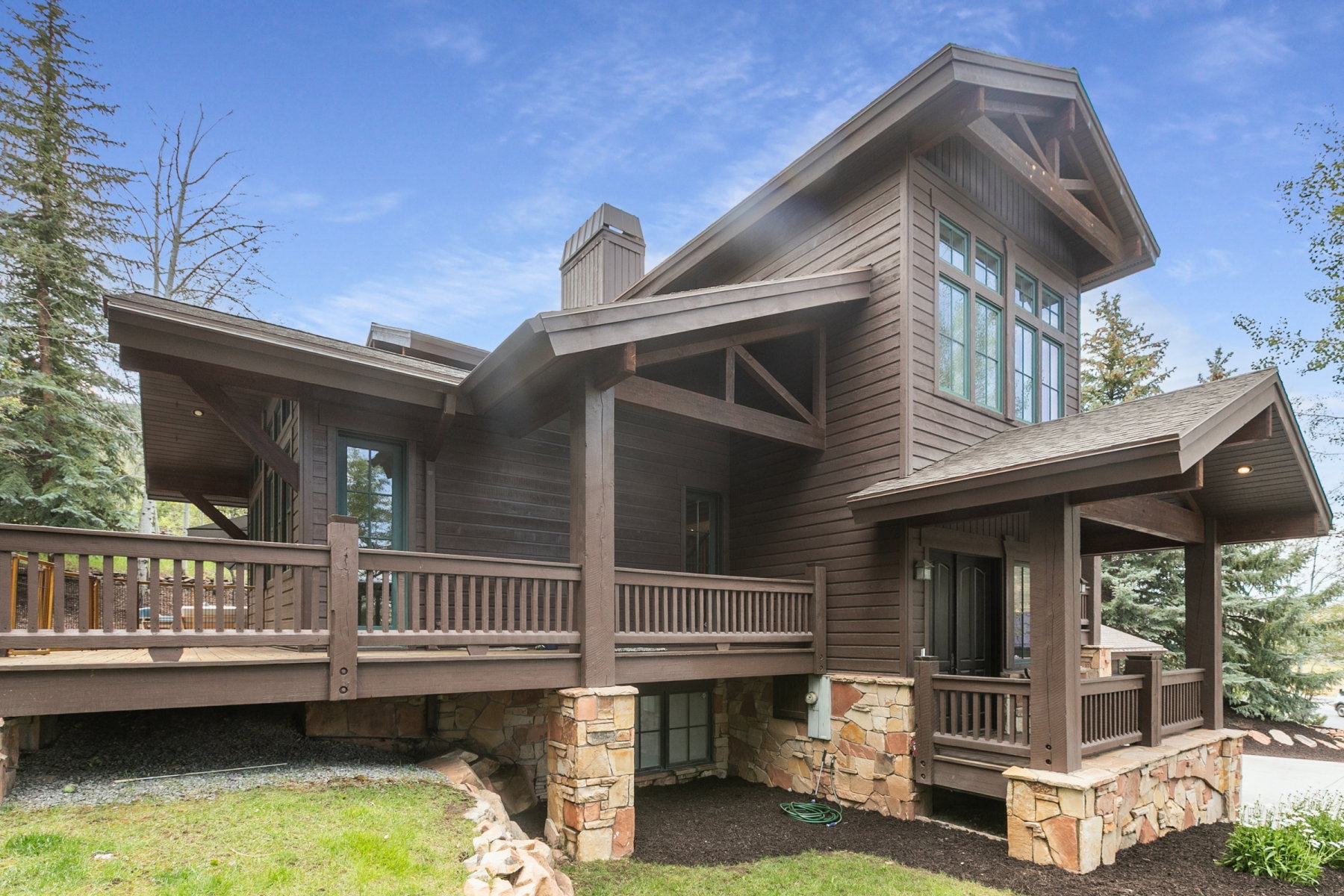 Lodge-style architecture featuring dark wood siding and a prominent chimney