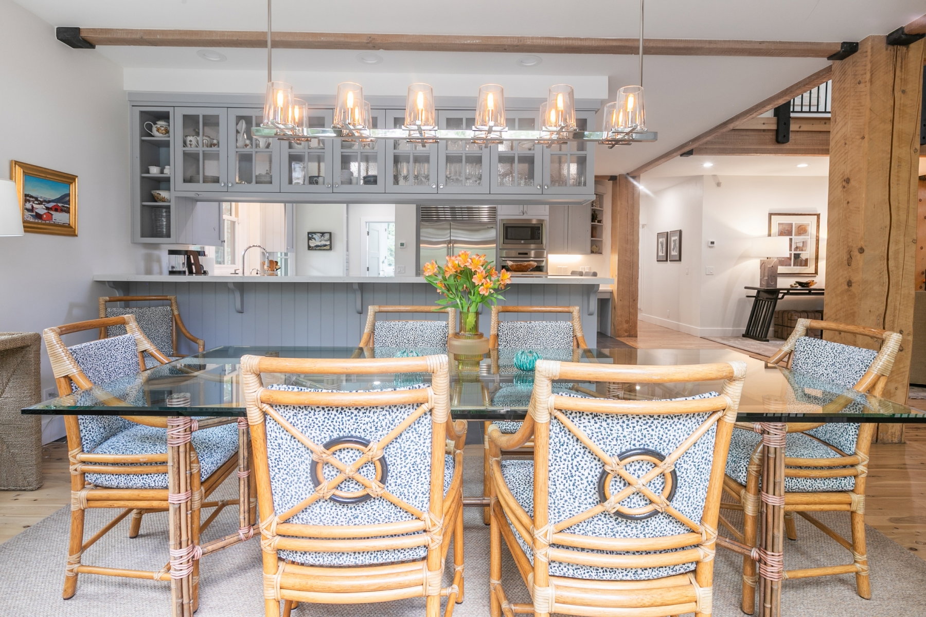Dining area featuring a linear chandelier and exposed wood beams