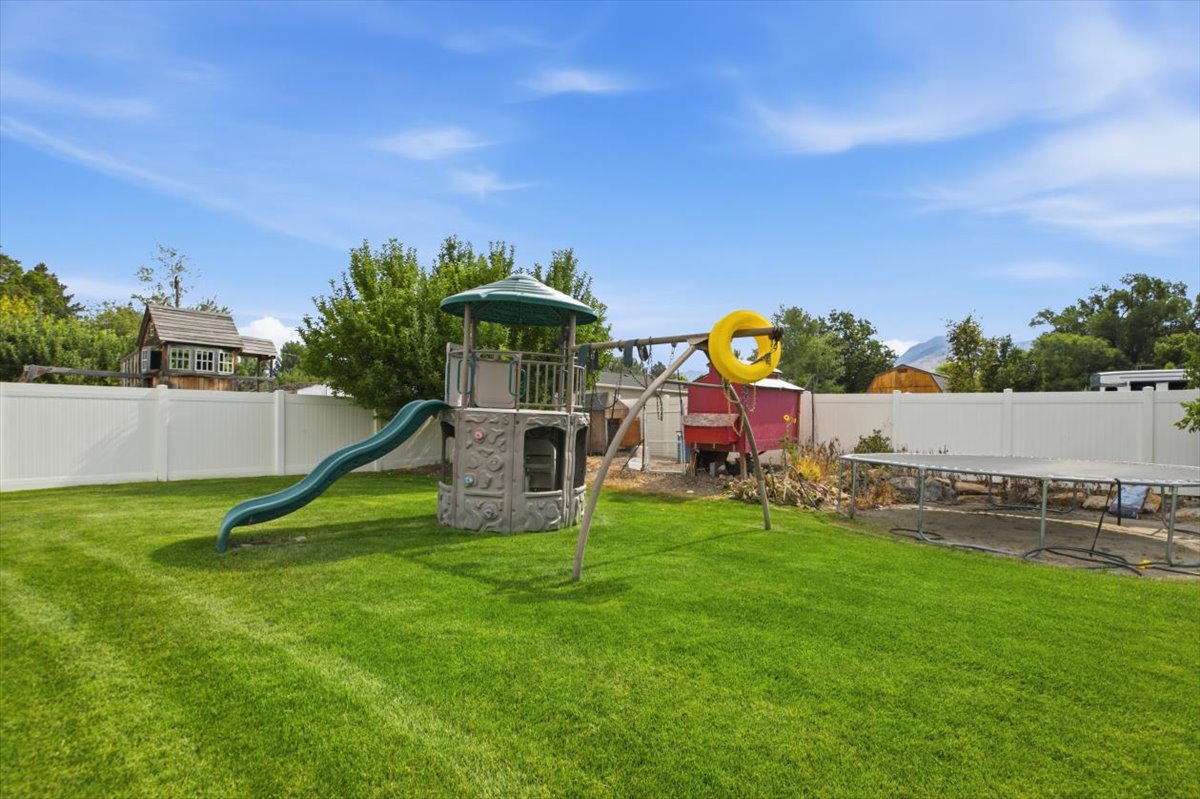 Expansive green lawn enclosed by a white privacy fence