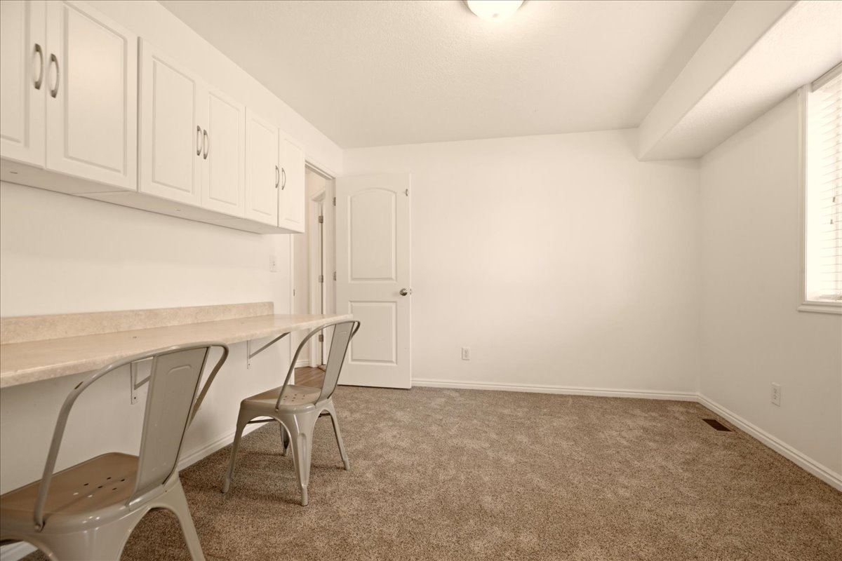 Built-in desk with countertop and overhead white cabinetry