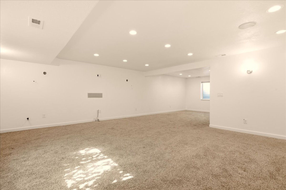 Spacious finished room featuring neutral carpeting and recessed ceiling lighting
