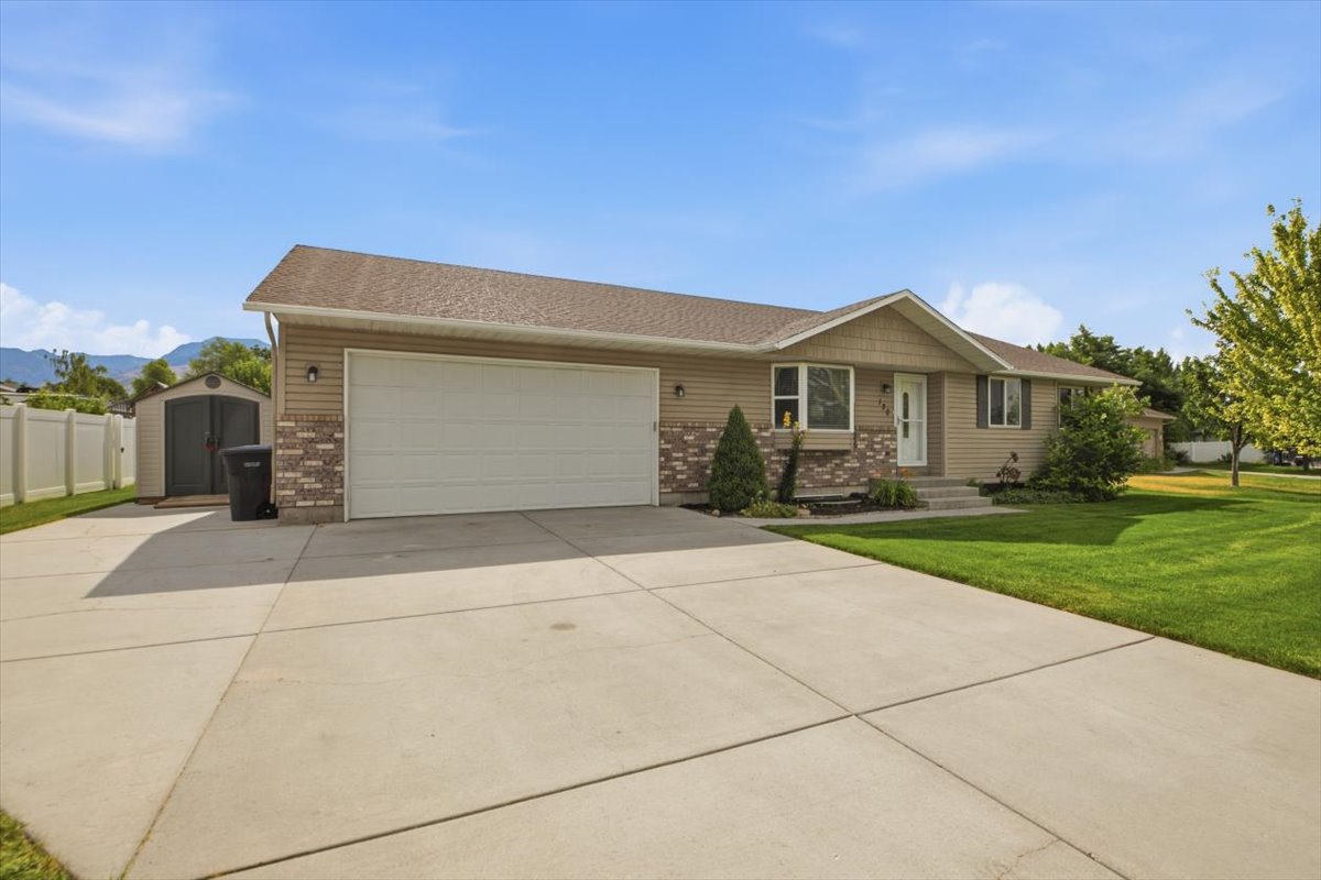 Contemporary home with a large concrete driveway, attached garage, and a gabled entry
