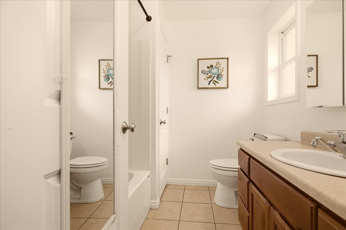 Bathroom featuring a vanity with dark wood-finish cabinetry, a light-colored countertop, and an integrated sink