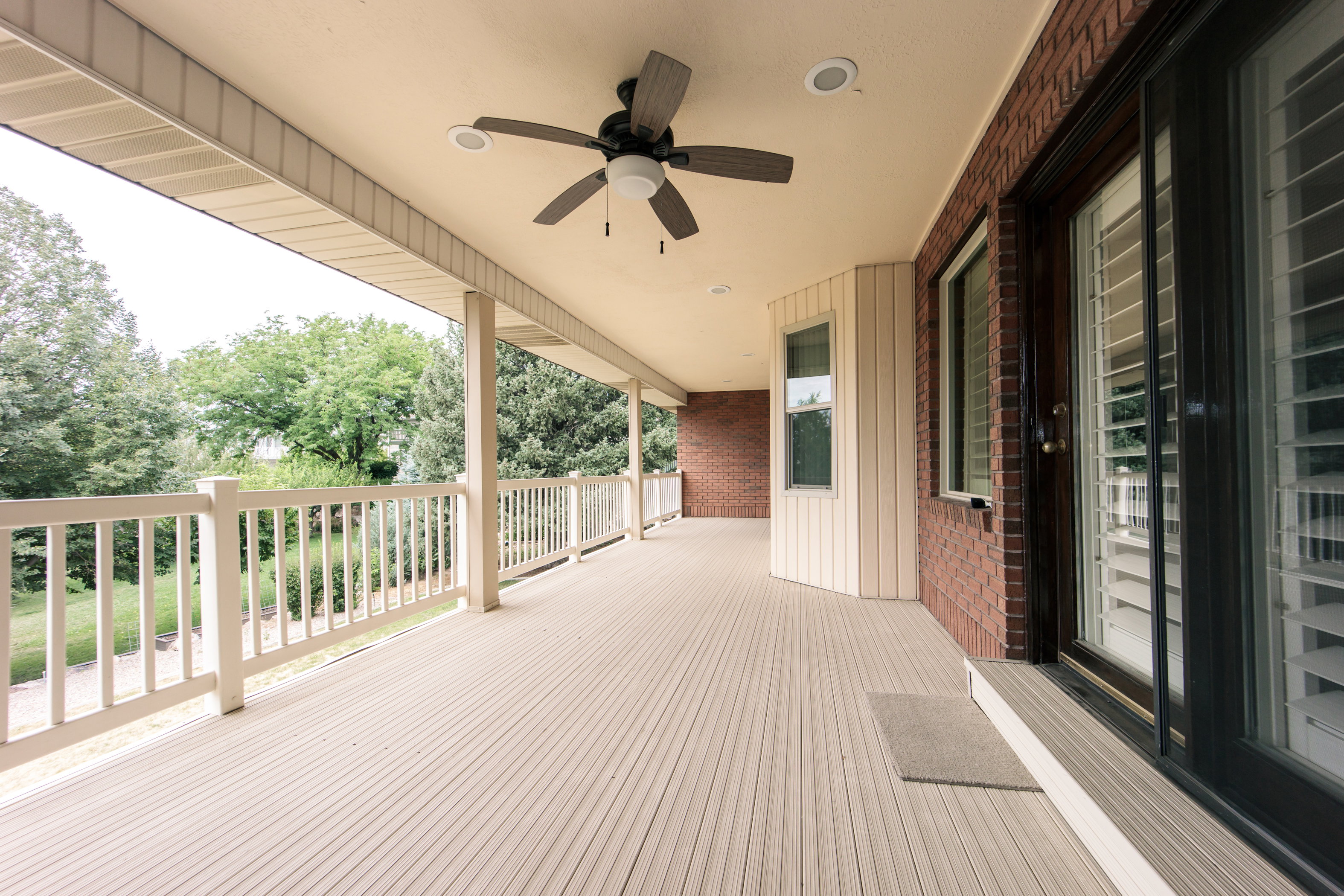 Expansive covered deck featuring composite decking and a white railing system
