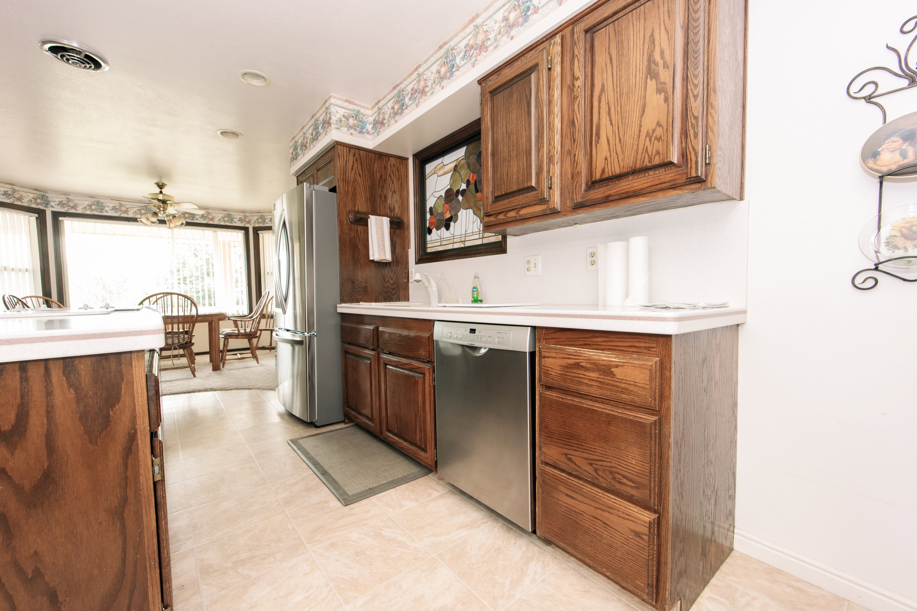 Kitchen featuring wood cabinetry, stainless steel appliances, and a tiled floor