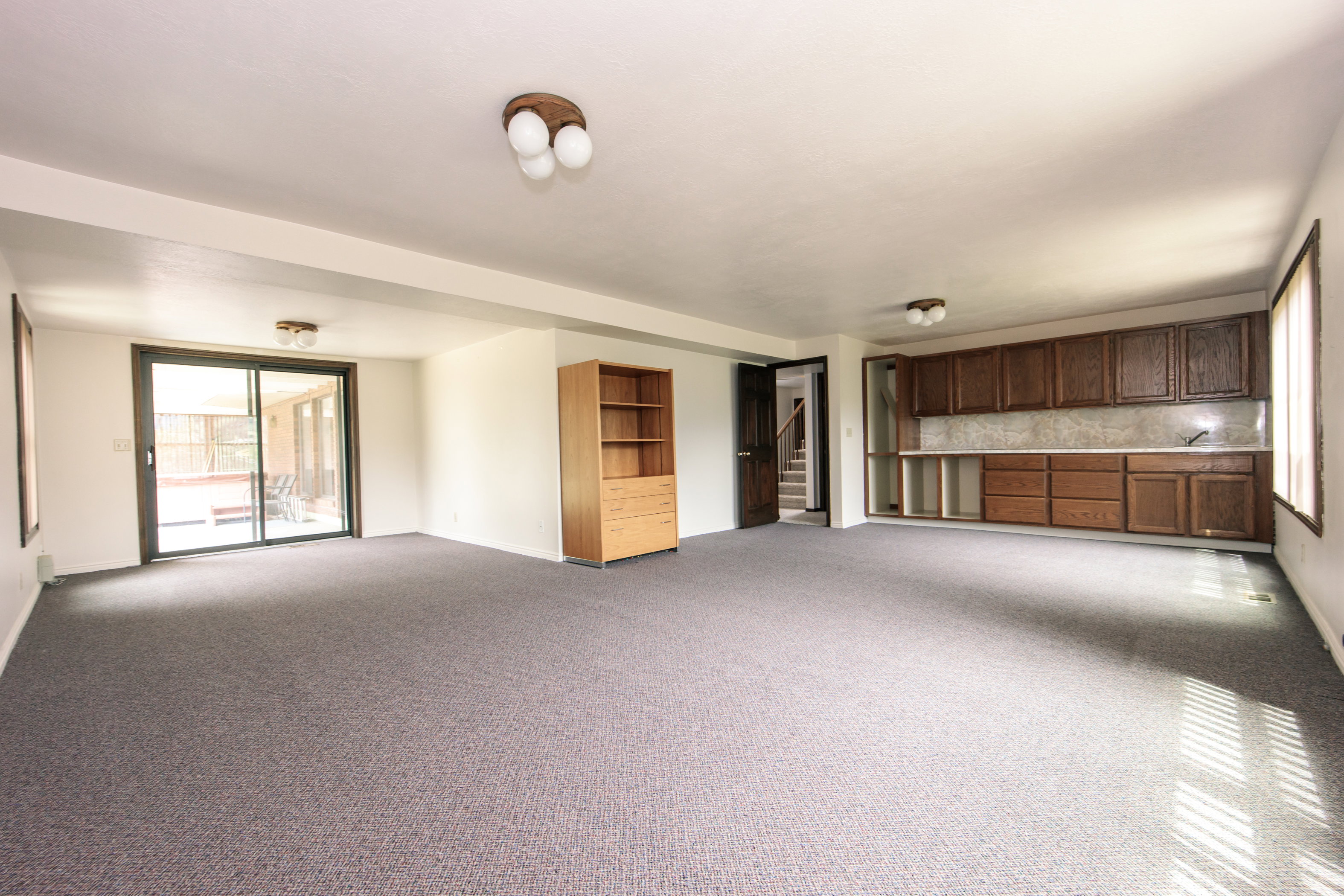 Spacious room featuring gray carpeting and white walls