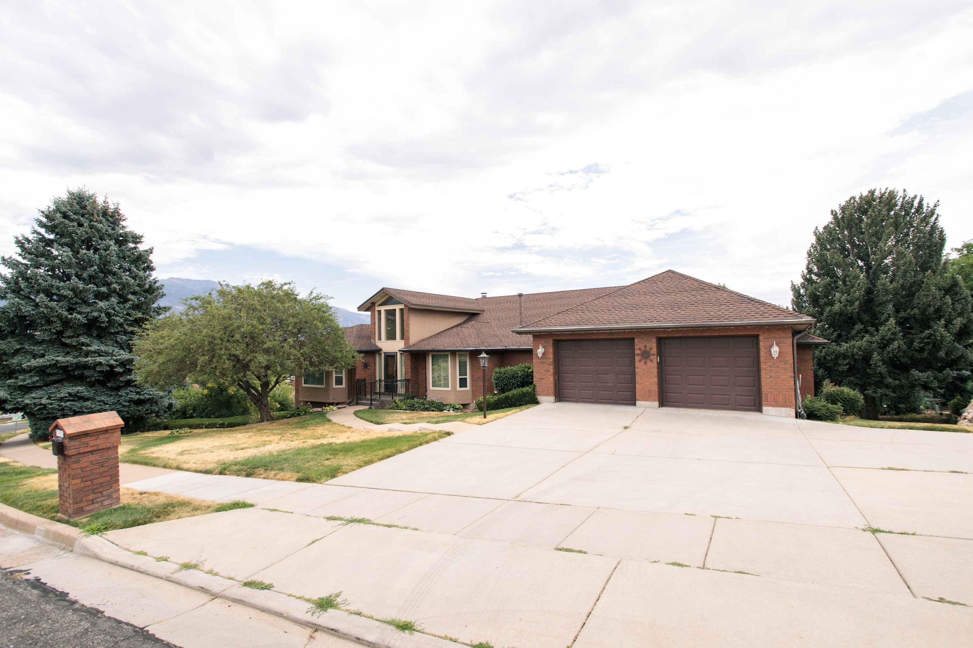 Brick and stucco exterior featuring a dual-bay garage with individual wood-finish doors