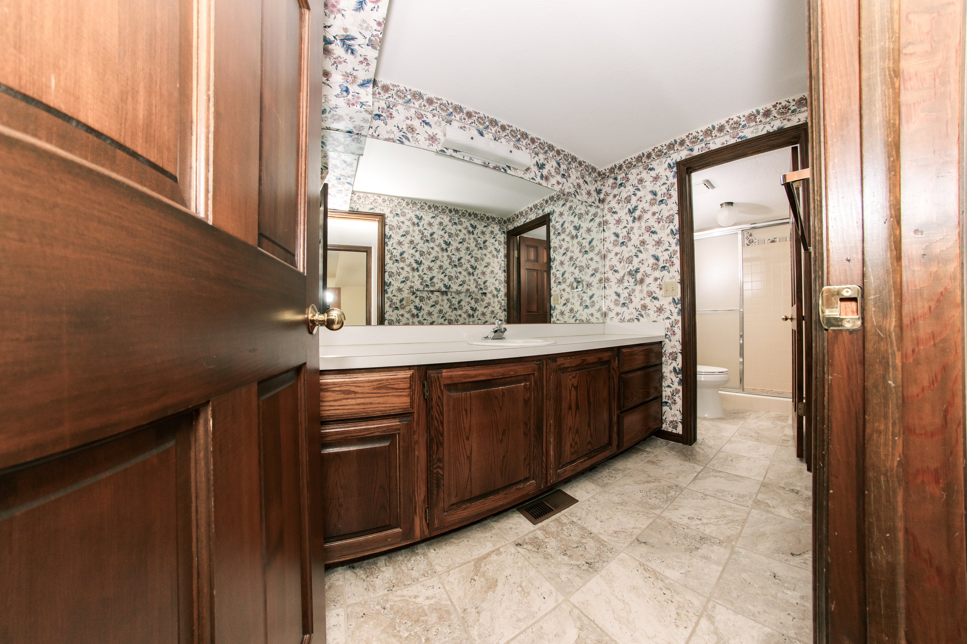 Bathroom featuring a spacious vanity with wood-finish cabinetry and a white countertop