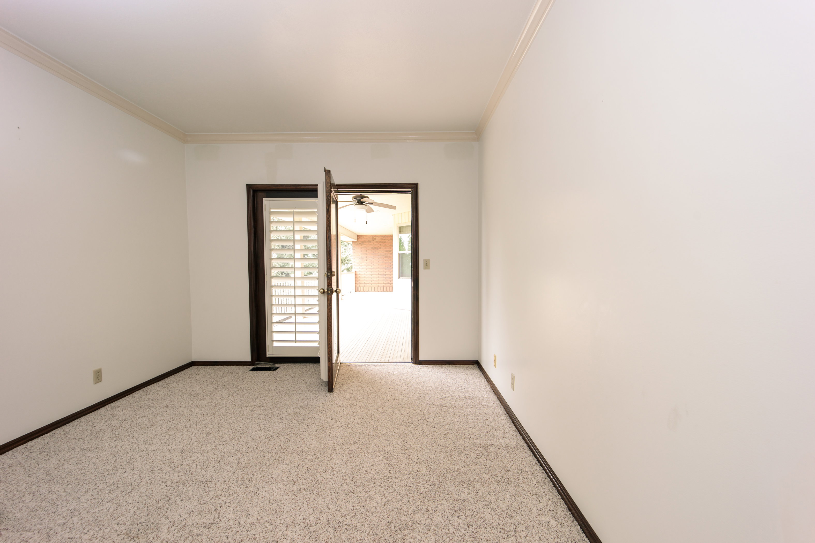 Room featuring light-toned carpet flooring, white walls, and dark baseboards