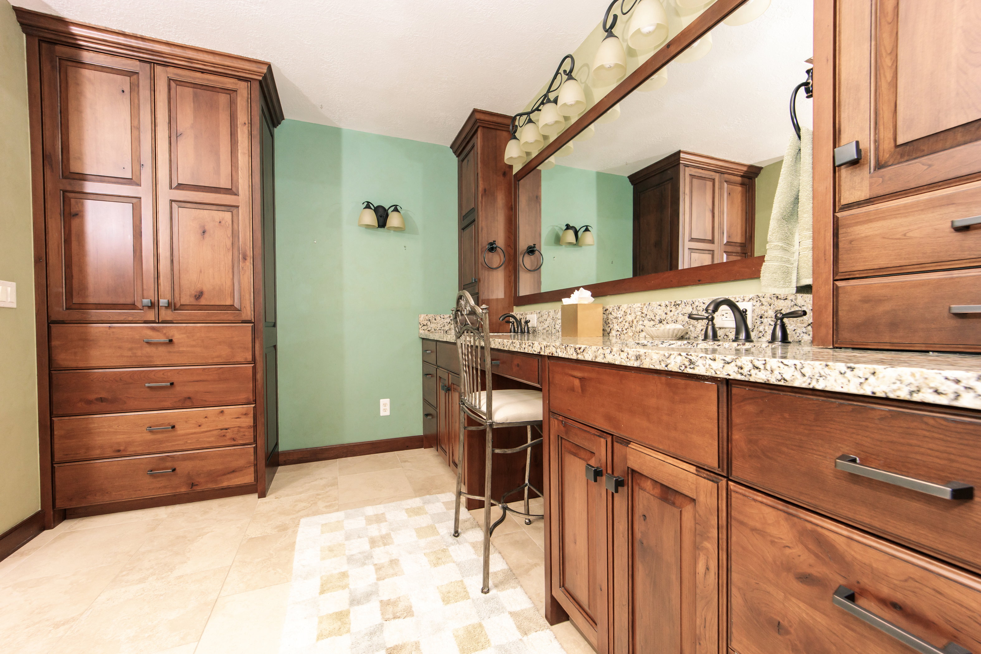 Bathroom vanity featuring double sinks with granite countertops and dark bronze hardware