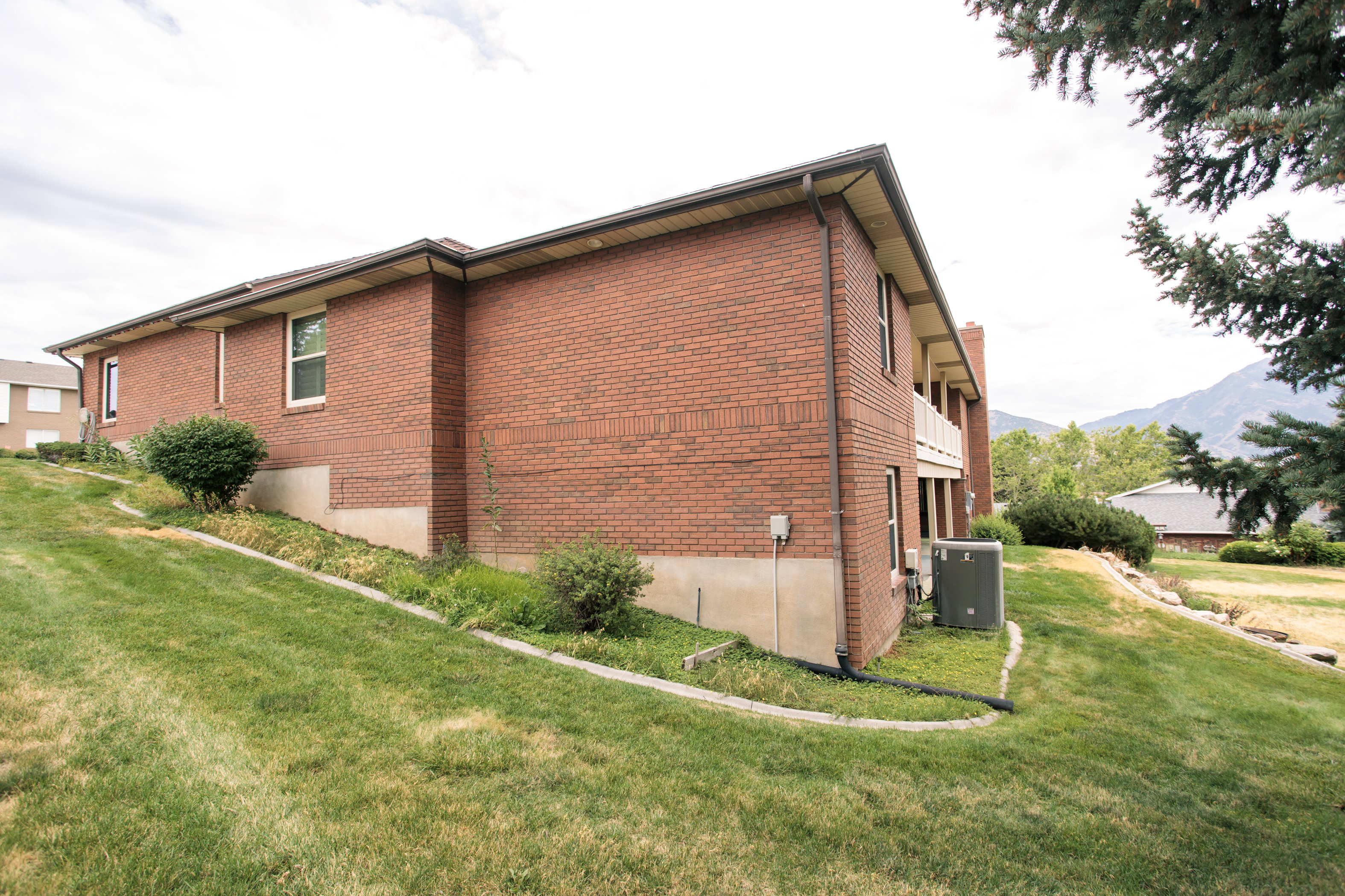 Brick exterior with a partial lower-level foundation and a balcony