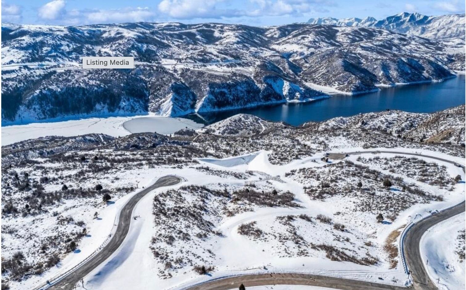Snow-covered mountainous terrain featuring a prominent body of water