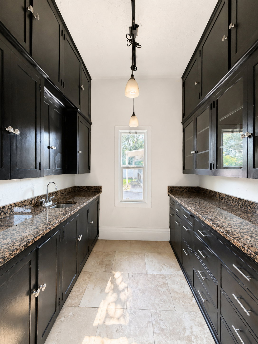 Butler Pantry/Wet Bar. featuring extensive dark cabinetry with varied hardware, granite countertops, and tile flooring