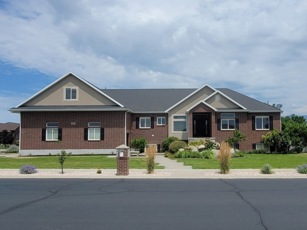 Brick and siding exterior with dark shingle roofing