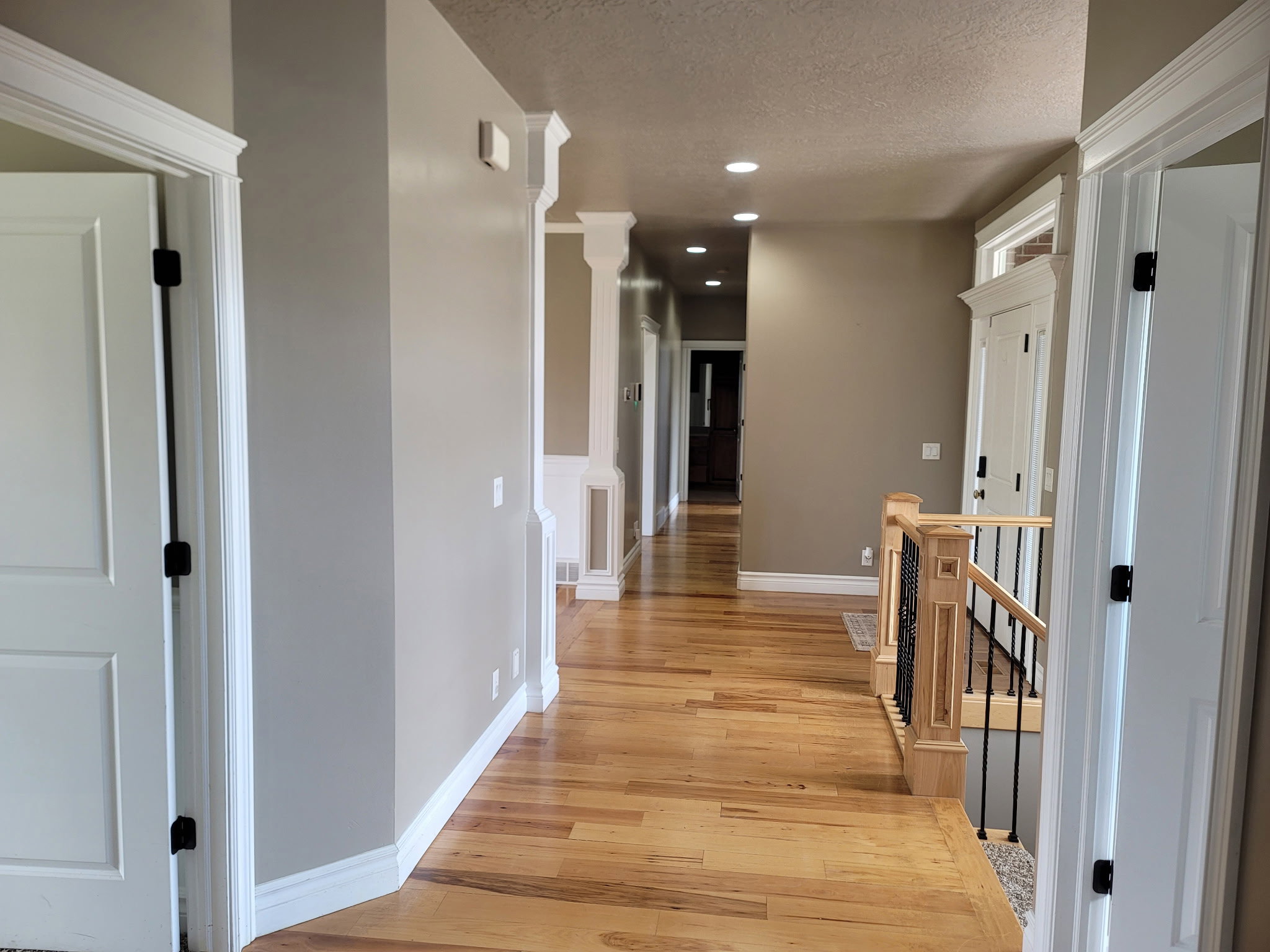 Hallway featuring wood-finish flooring, recessed lighting, and white trim