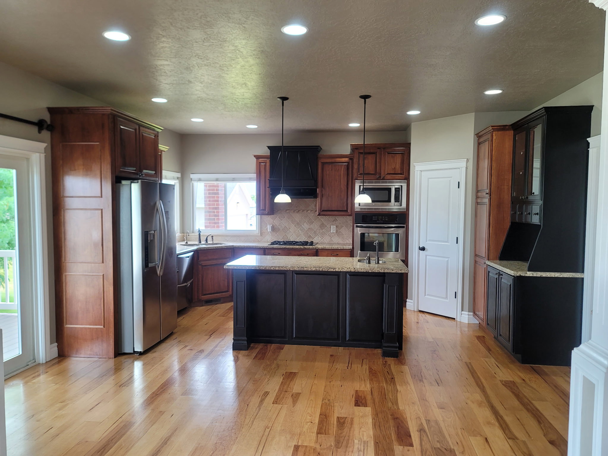 Kitchen featuring wood-finish flooring, recessed lighting, and a central island with a granite countertop