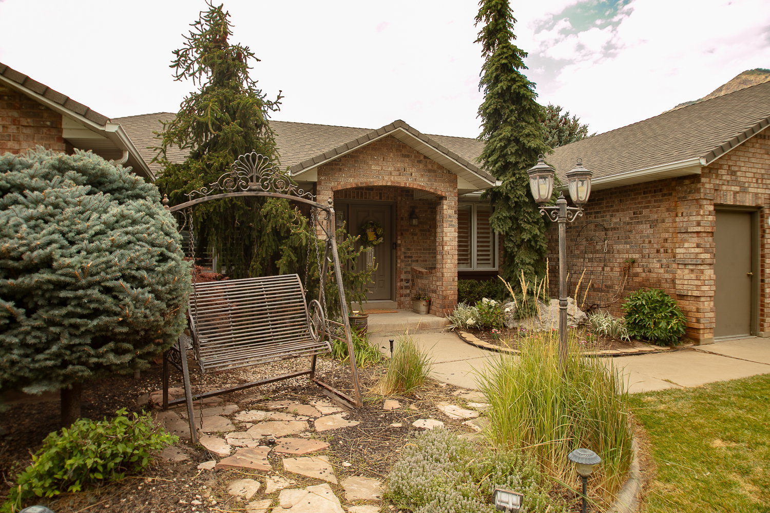 Brick exterior featuring a covered entry and an attached garage