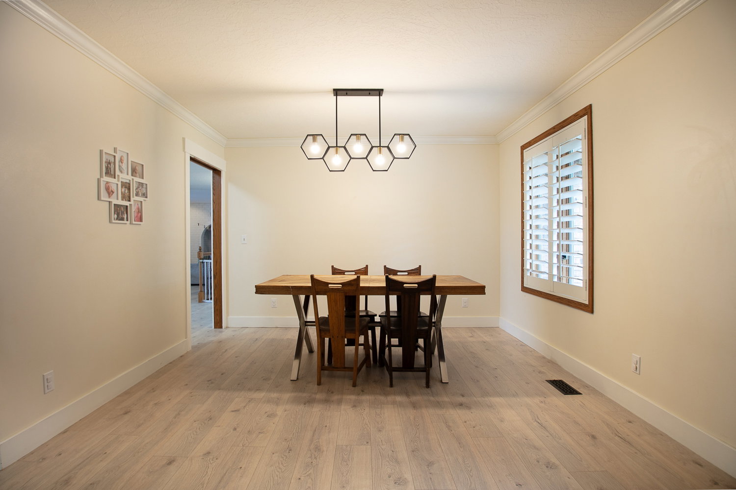 Inviting interior space featuring light wood-finish flooring, crisp white baseboards, and crown molding
