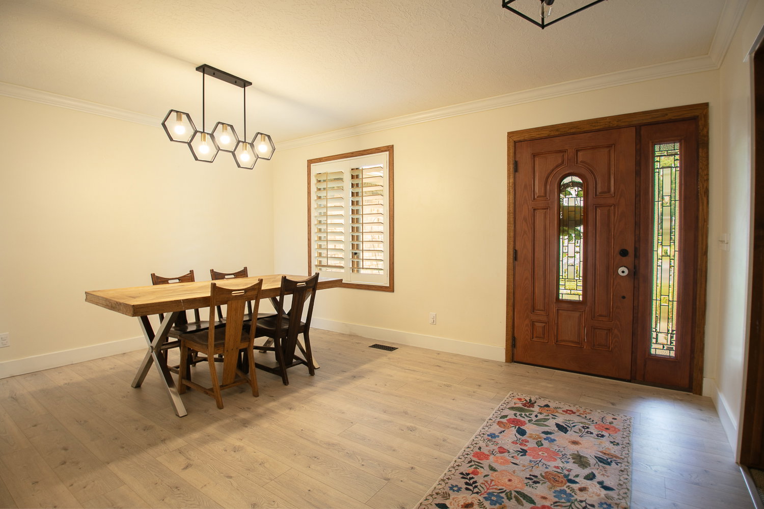 Light wood-finish flooring complements the crown molding and baseboards