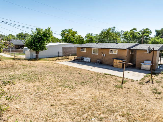 Rear exterior of the property featuring brown siding and a concrete patio