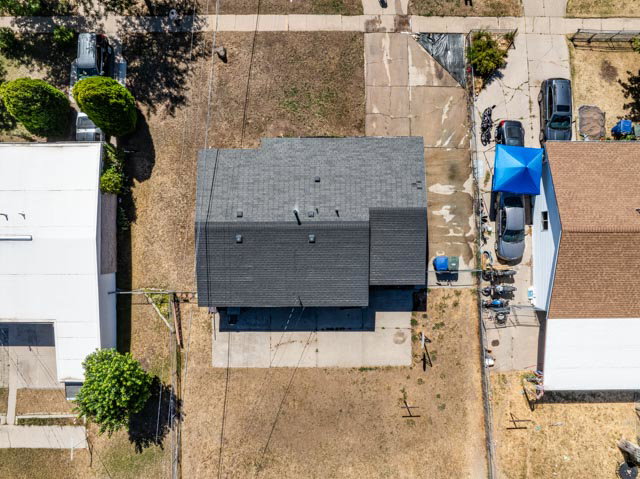 Property featuring a dark shingle roof, concrete driveways, and an expansive lot