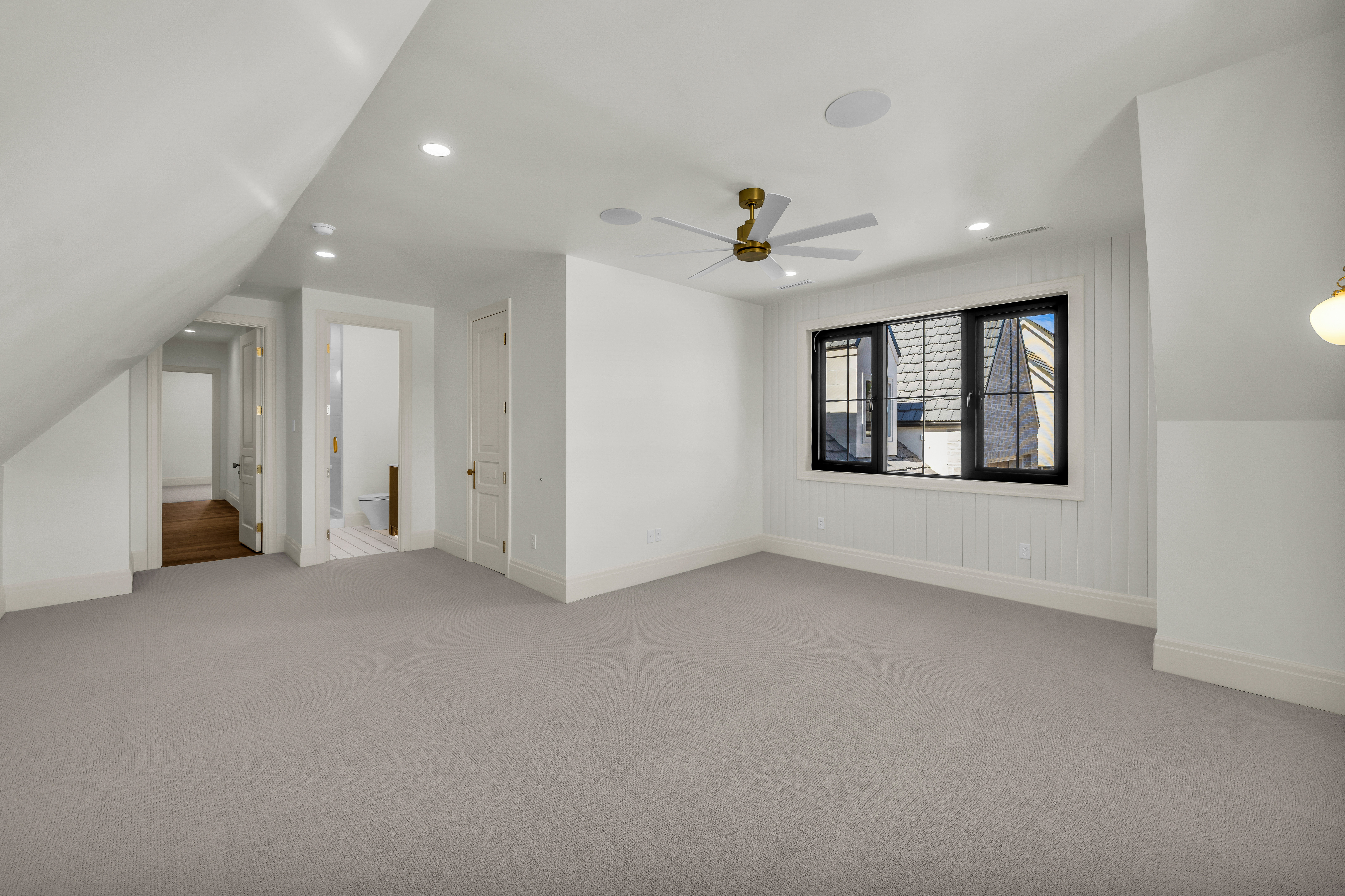 Spacious room featuring vaulted ceilings, recessed lighting, and light gray carpeting