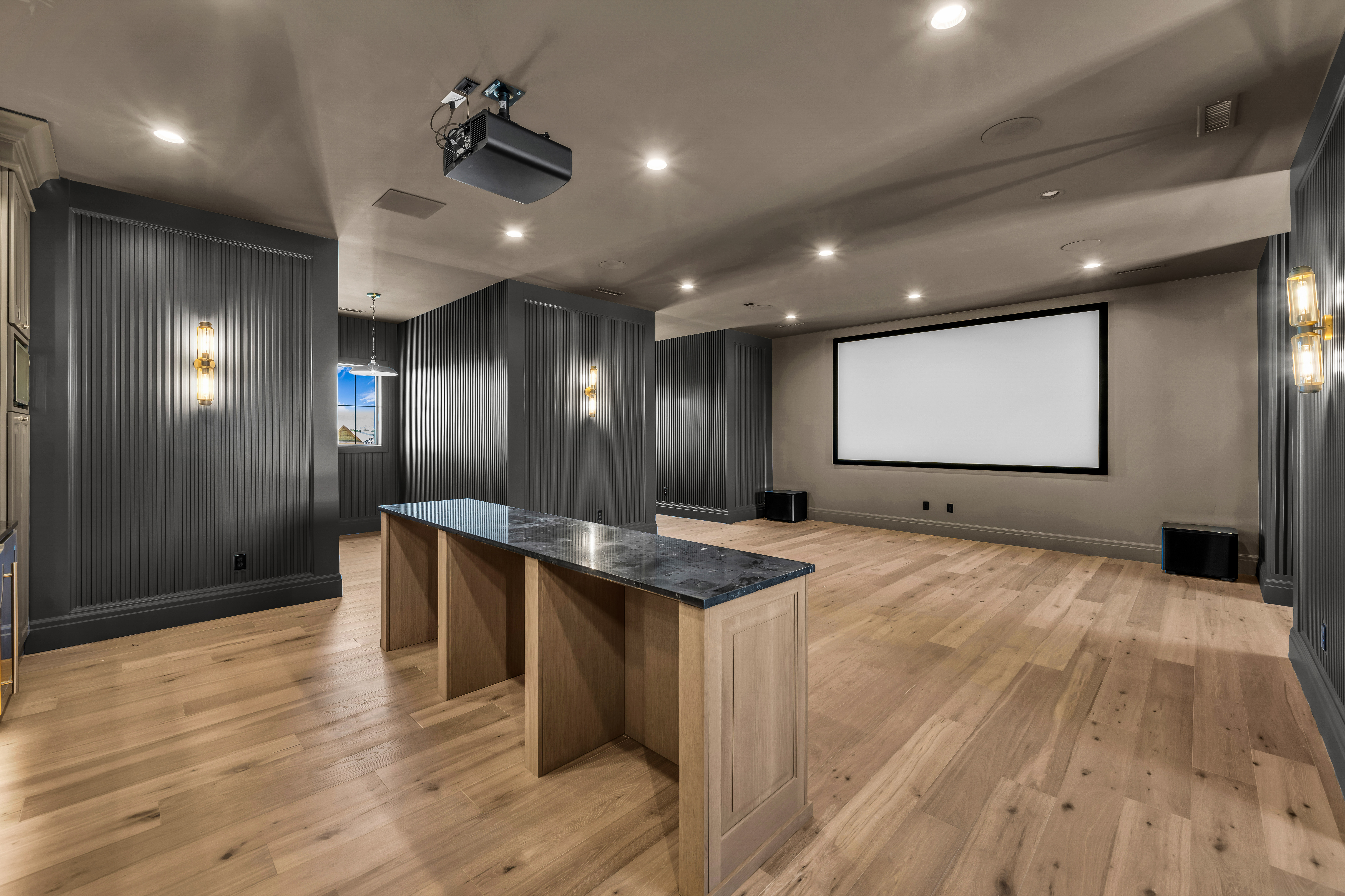 Dedicated media room featuring a large projection screen and ceiling-mounted projector