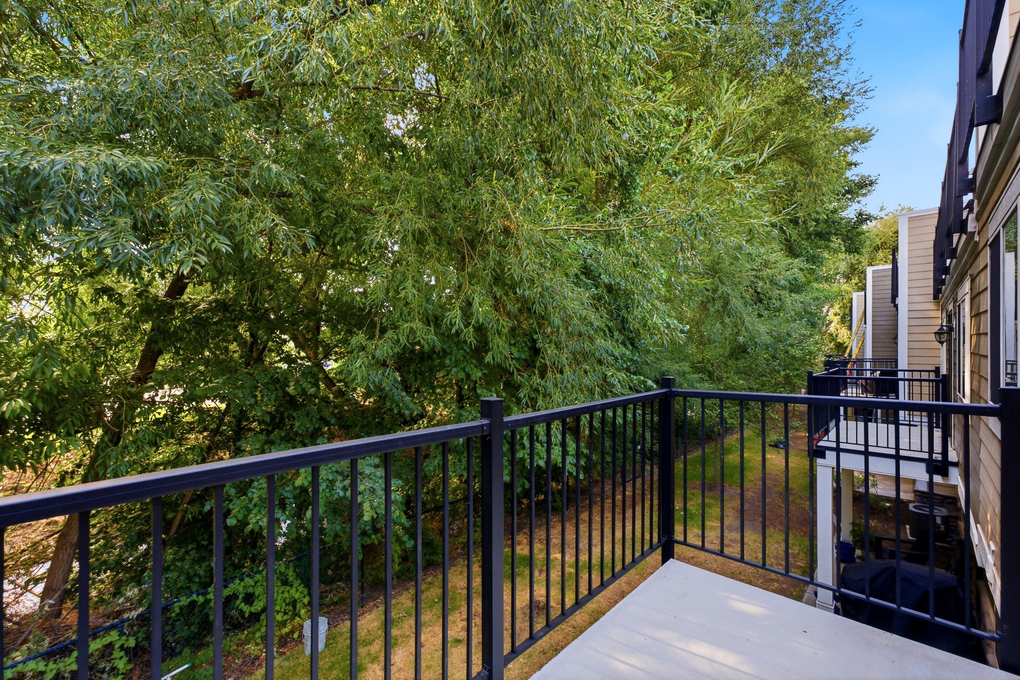 Private balcony featuring black metal railings and a concrete surface