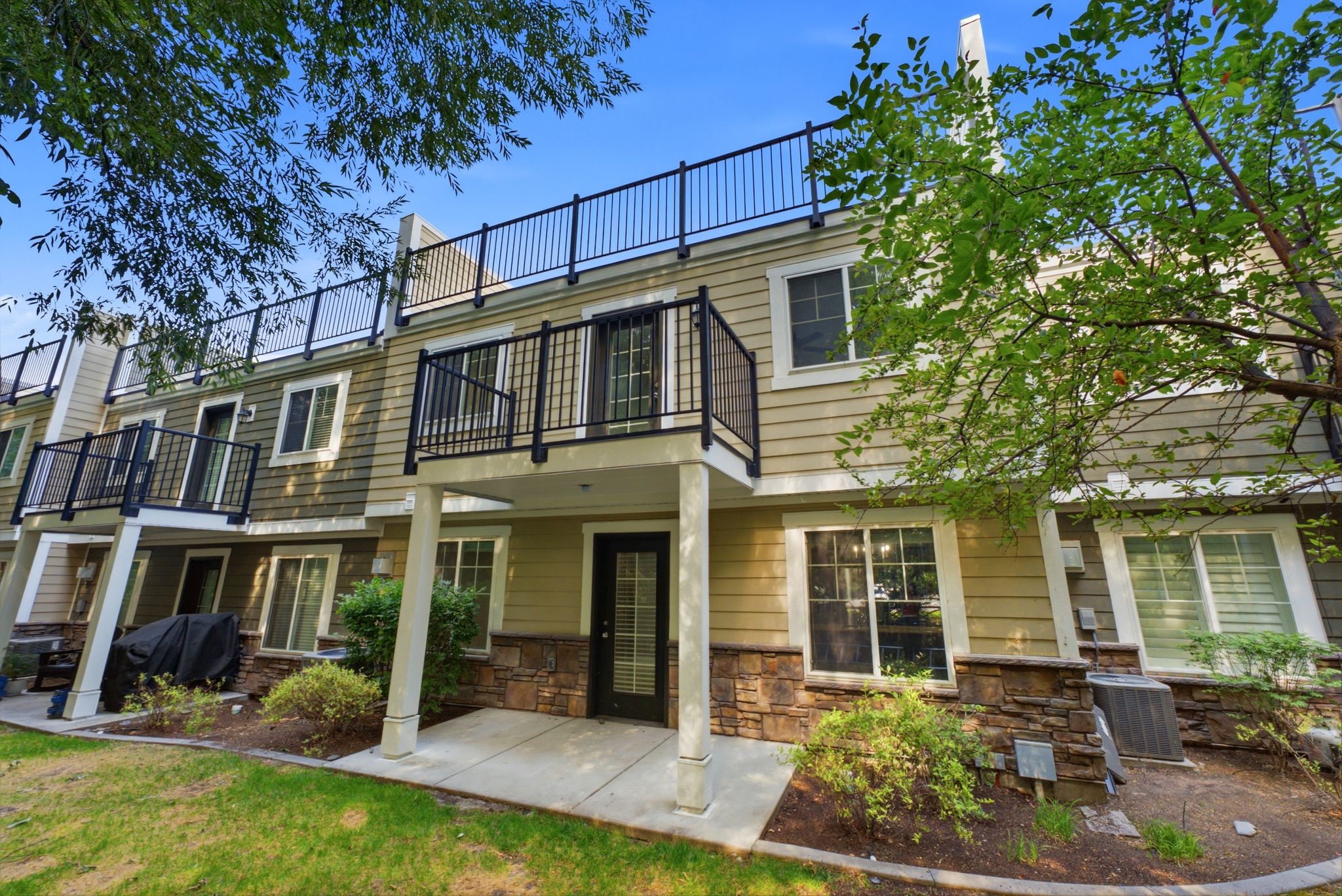 Townhome with a large rooftop deck, a private primary suite deck, and back patio.
