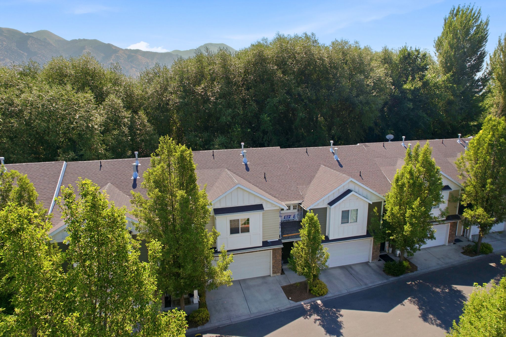 Row of townhomes featuring attached garages and individual driveways