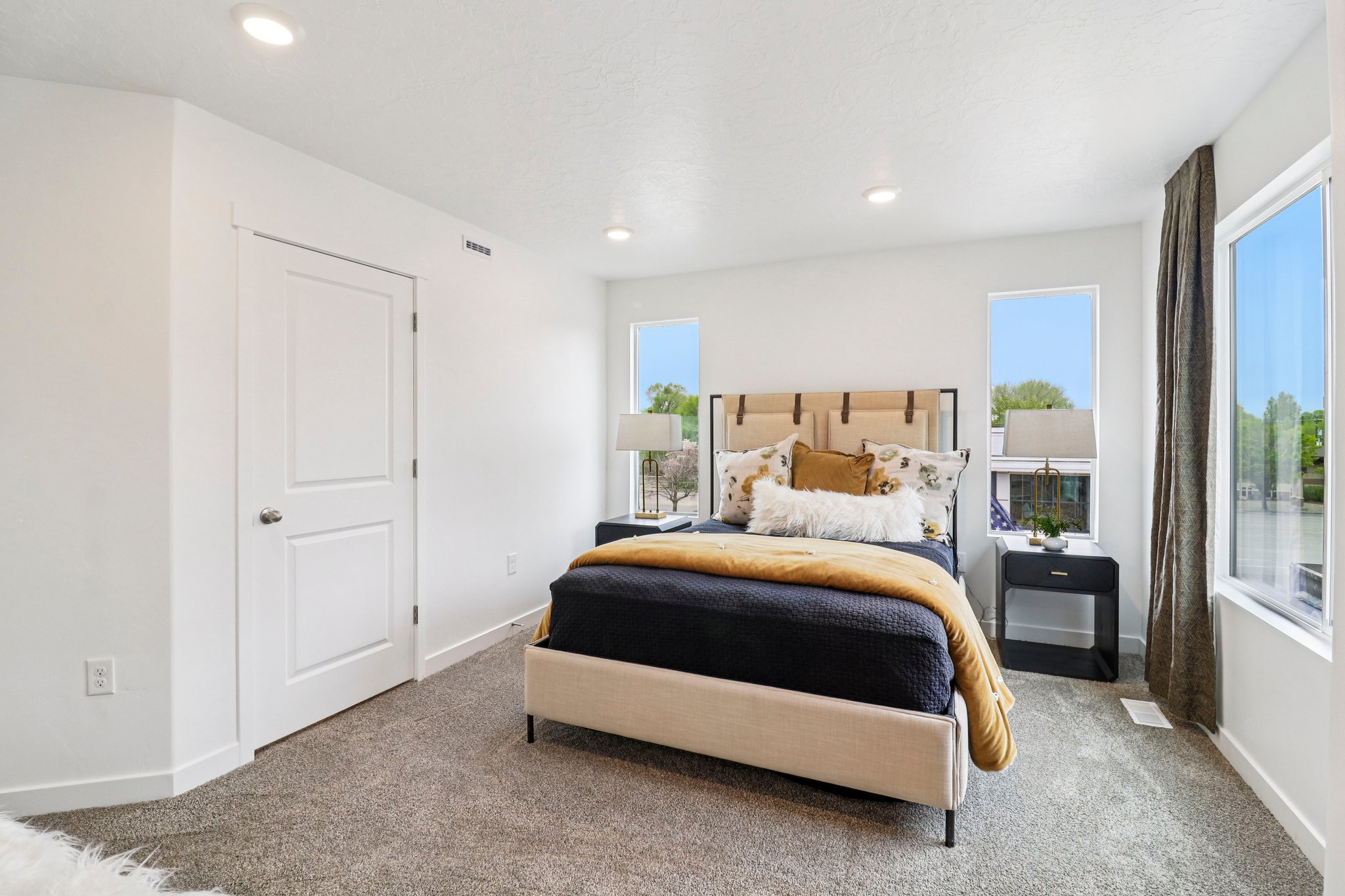 Spacious room featuring neutral carpeting, recessed lighting, white walls, and a two-panel interior door