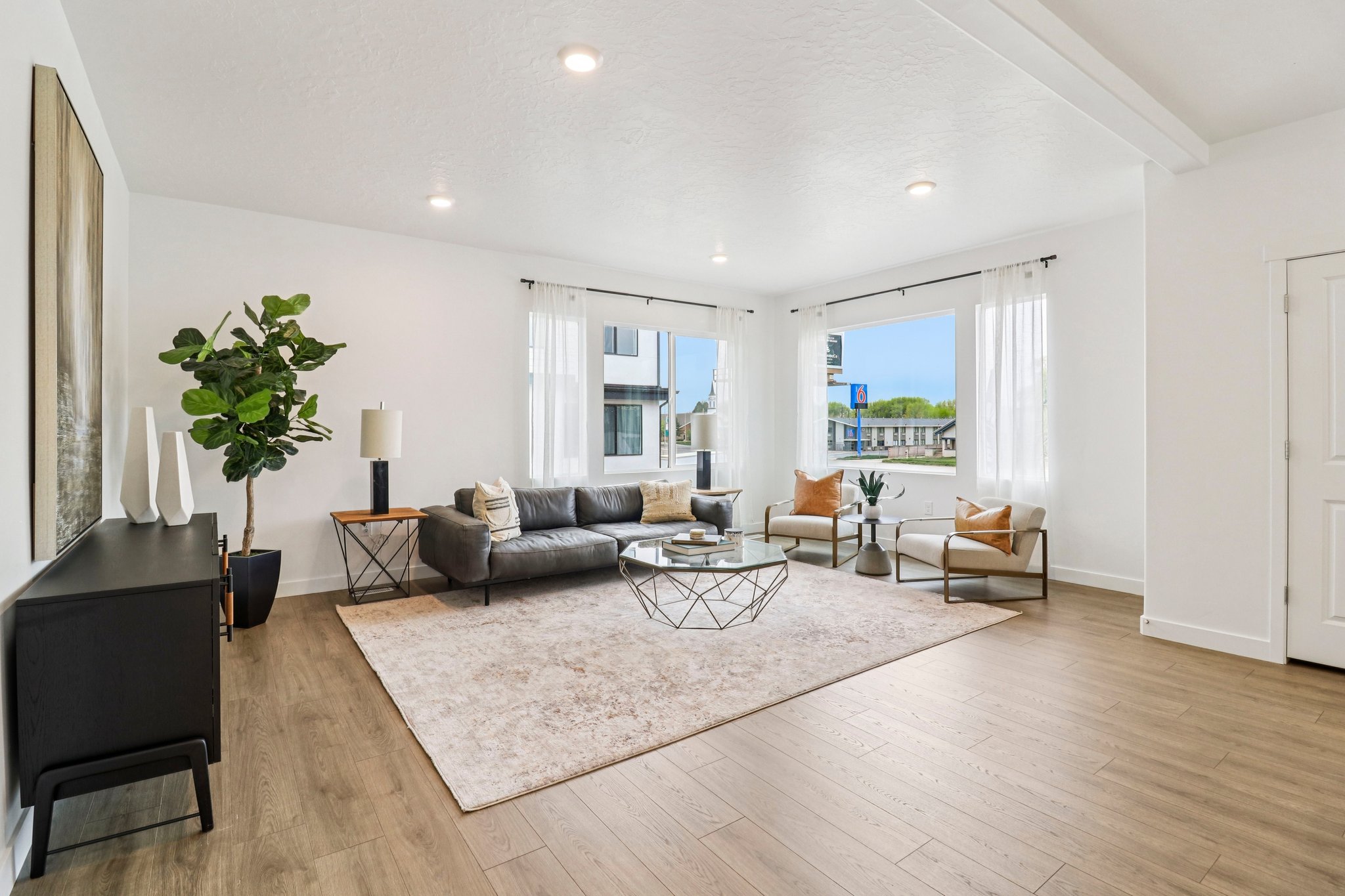 Spacious living area featuring light wood-finish flooring and recessed lighting