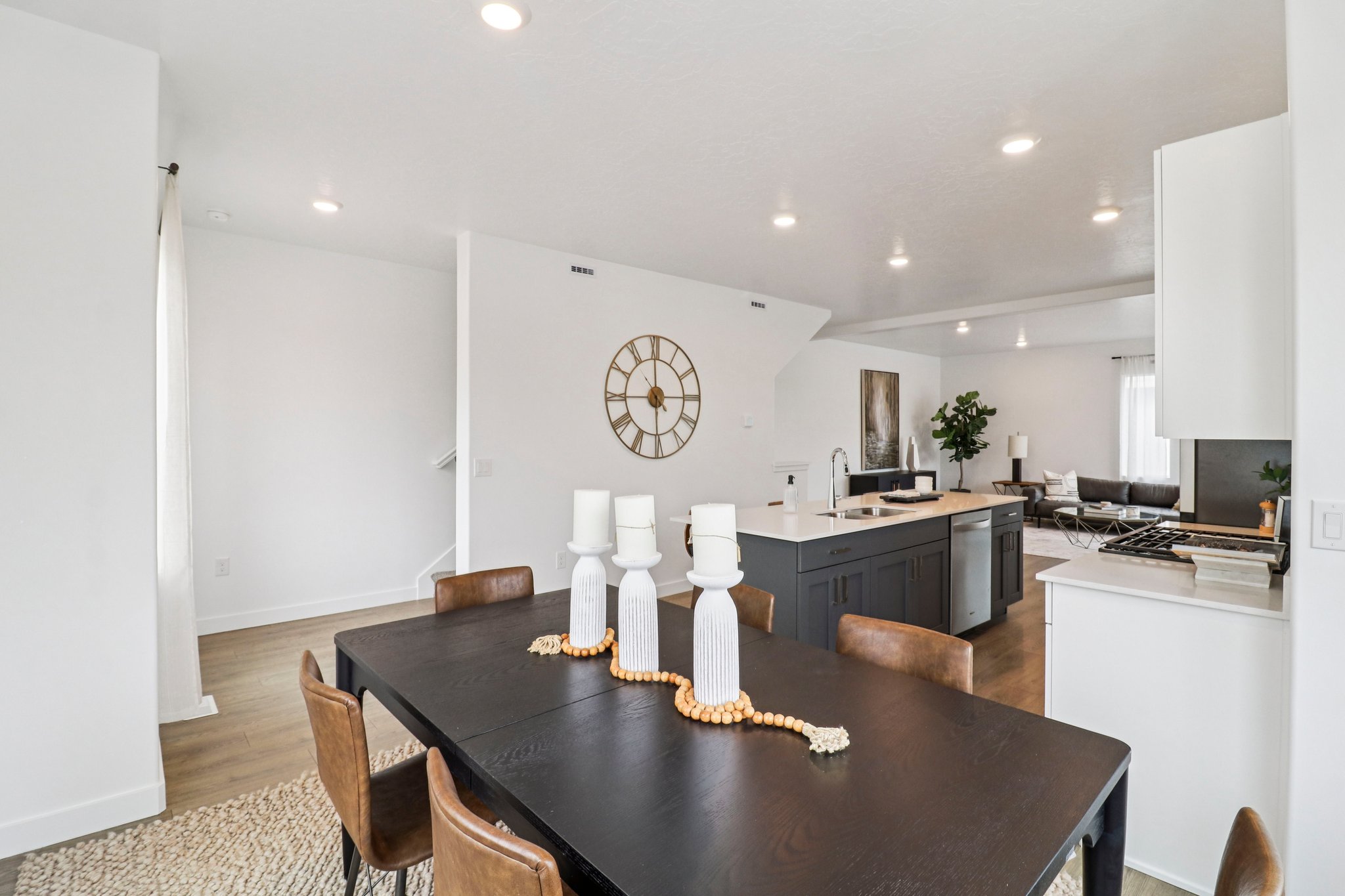 Open-concept living space featuring wood-finish flooring, recessed lighting, and a white color palette
