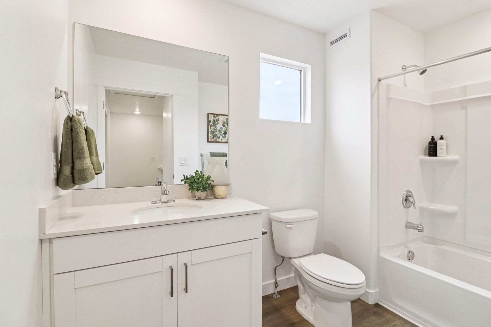 Contemporary bathroom featuring a white vanity with a light-toned countertop, a rectangular undermount sink, and a chrome faucet