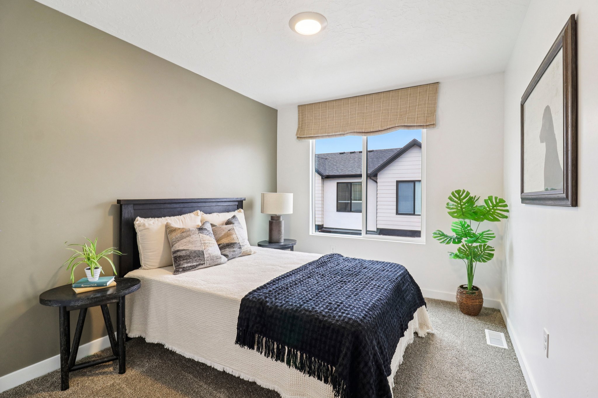 Carpeted room featuring a single window with a woven shade, recessed ceiling light, and a two-tone wall treatment