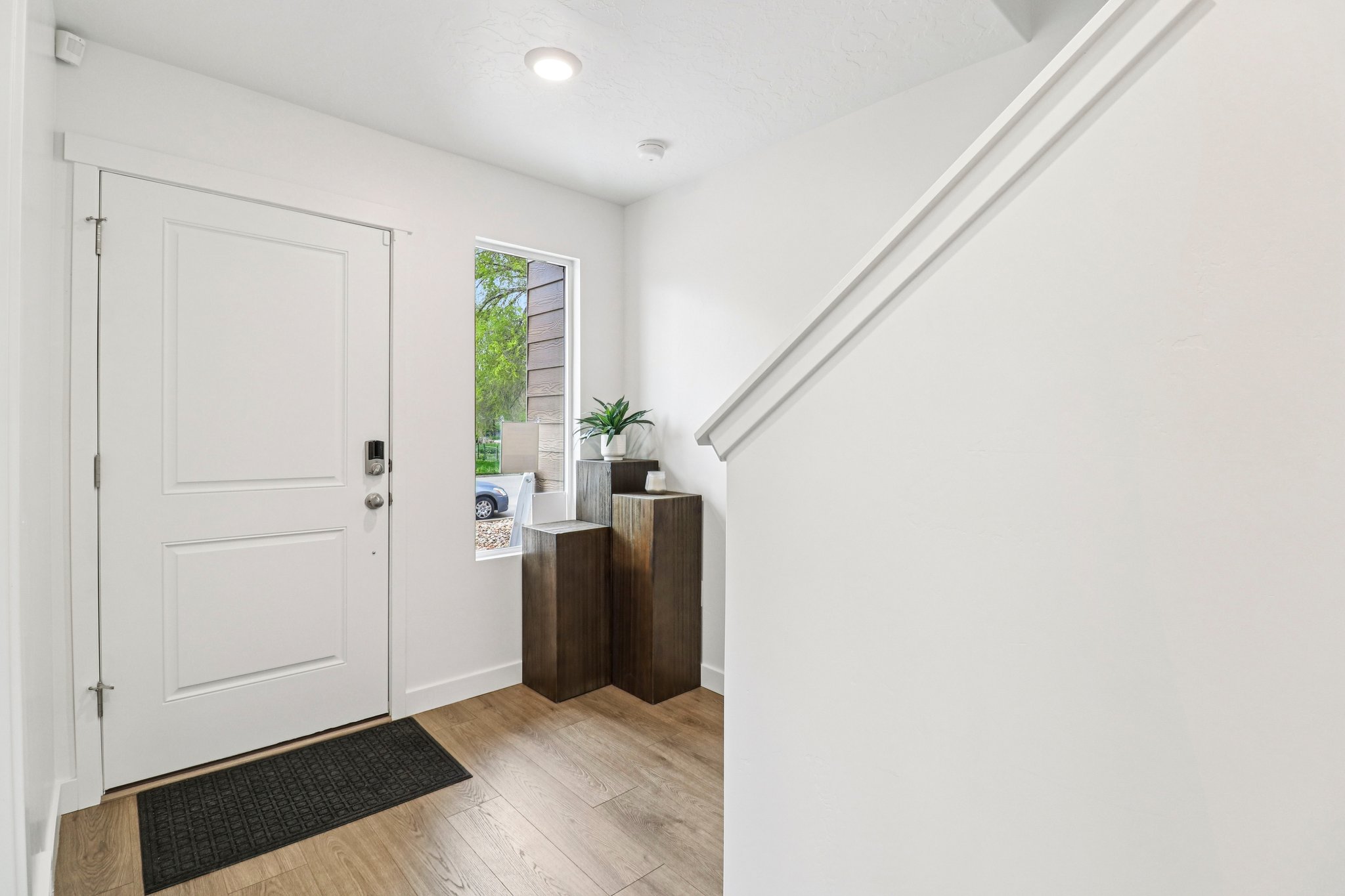 Entryway featuring a white paneled door with smart lock hardware, a window, wood-finish flooring, and bright recessed lighting