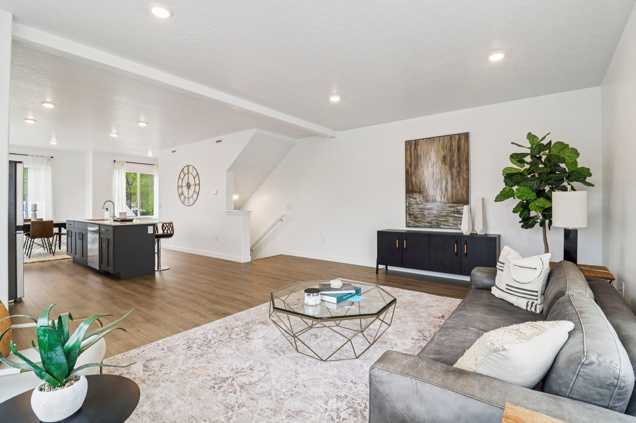 Open-concept living space featuring wood-finish flooring, recessed lighting, and a white color palette