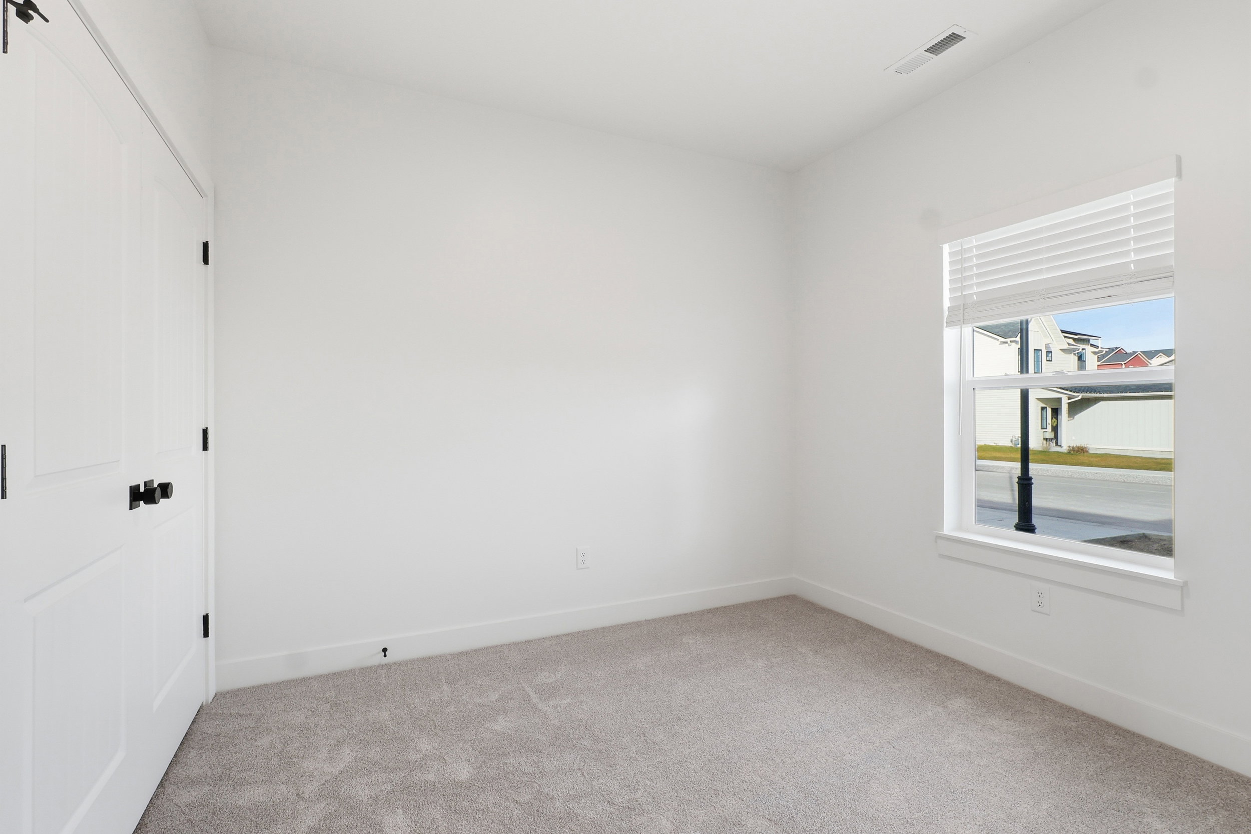 Neutral-toned carpeting complements the pristine white walls and trim