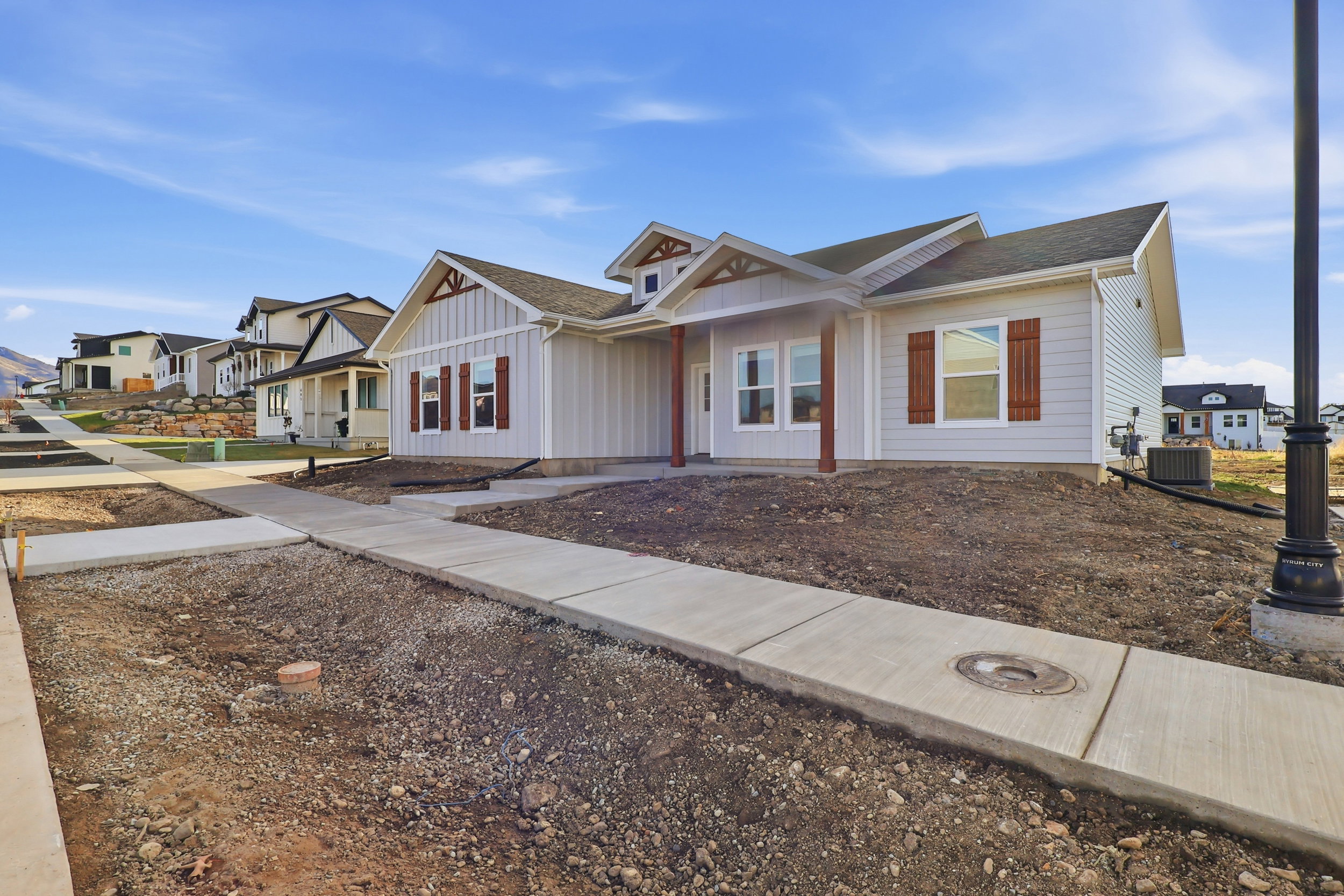 Single-story home featuring light-colored siding and a dark shingle roof