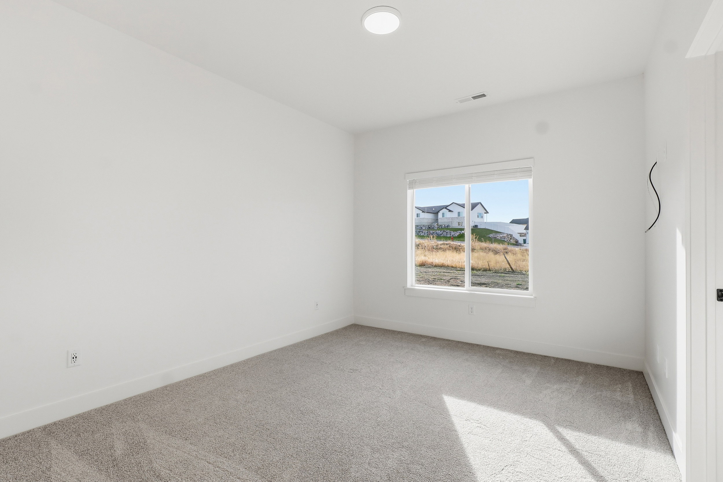 Neutral-toned carpeting and white walls create a bright interior
