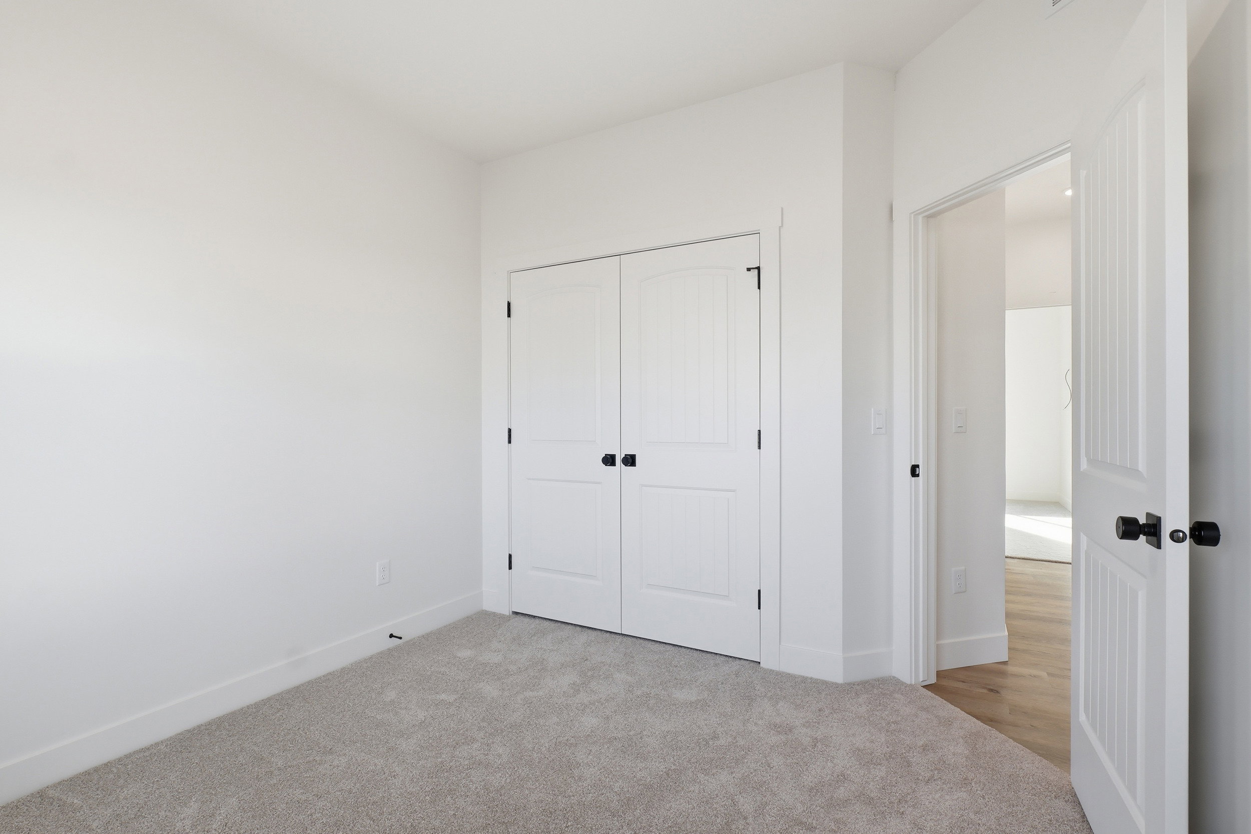 Bedroom featuring neutral carpeting, white painted walls, and white trim