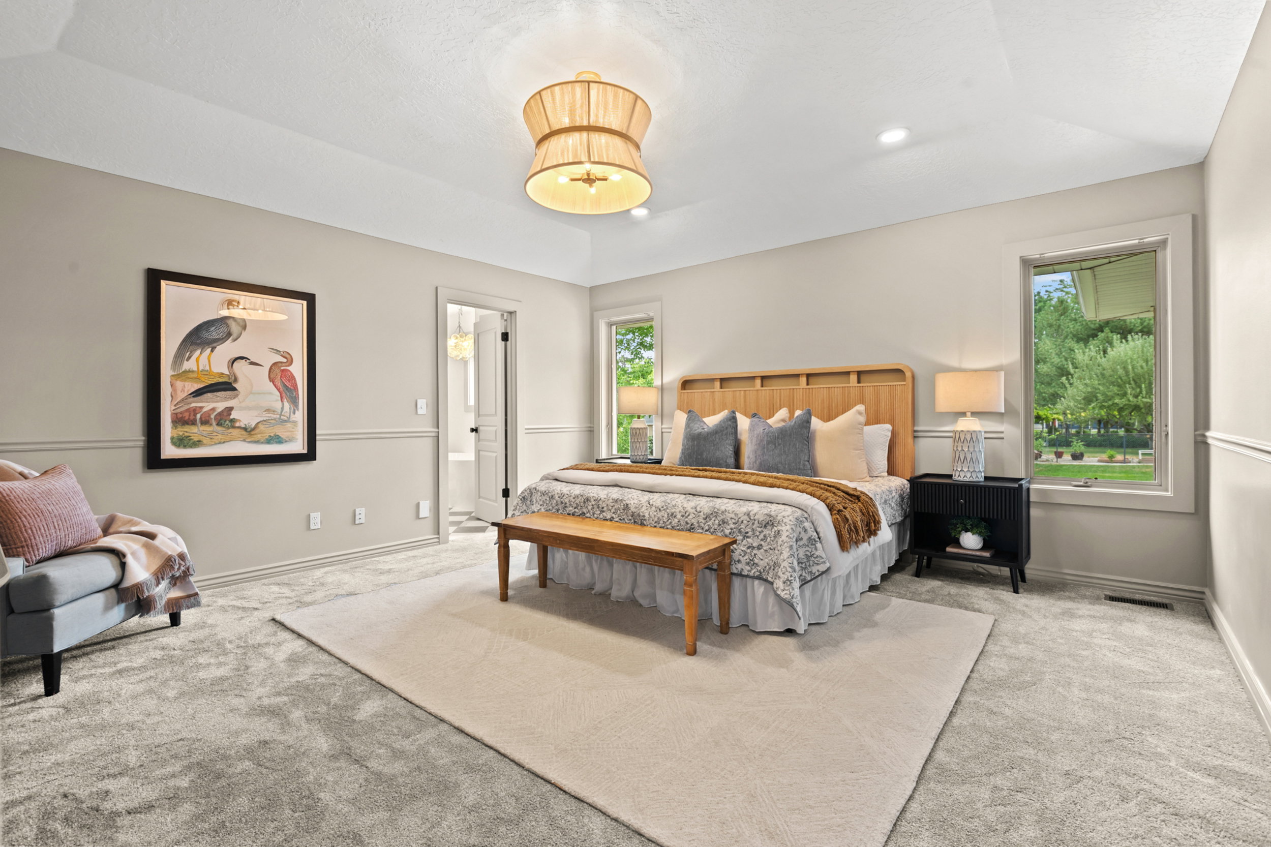Spacious room featuring tray ceiling, recessed lighting, and wall paneling