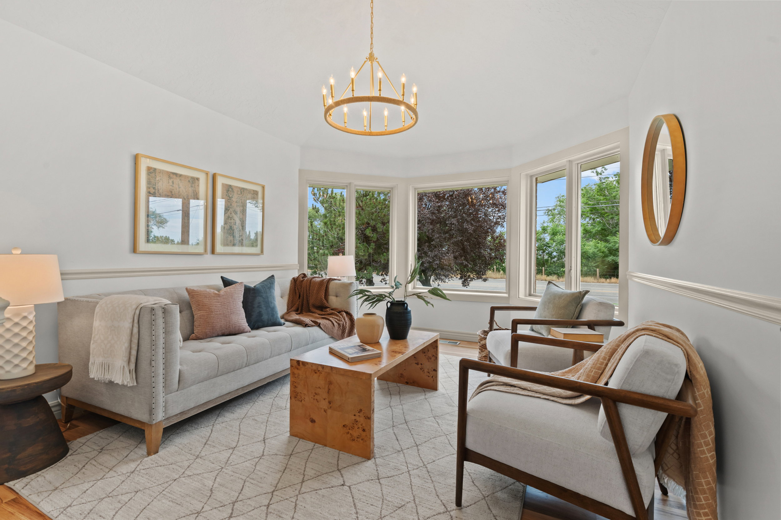 Bay window with multiple large panes, crown molding, wood-finish flooring, and a brass chandelier