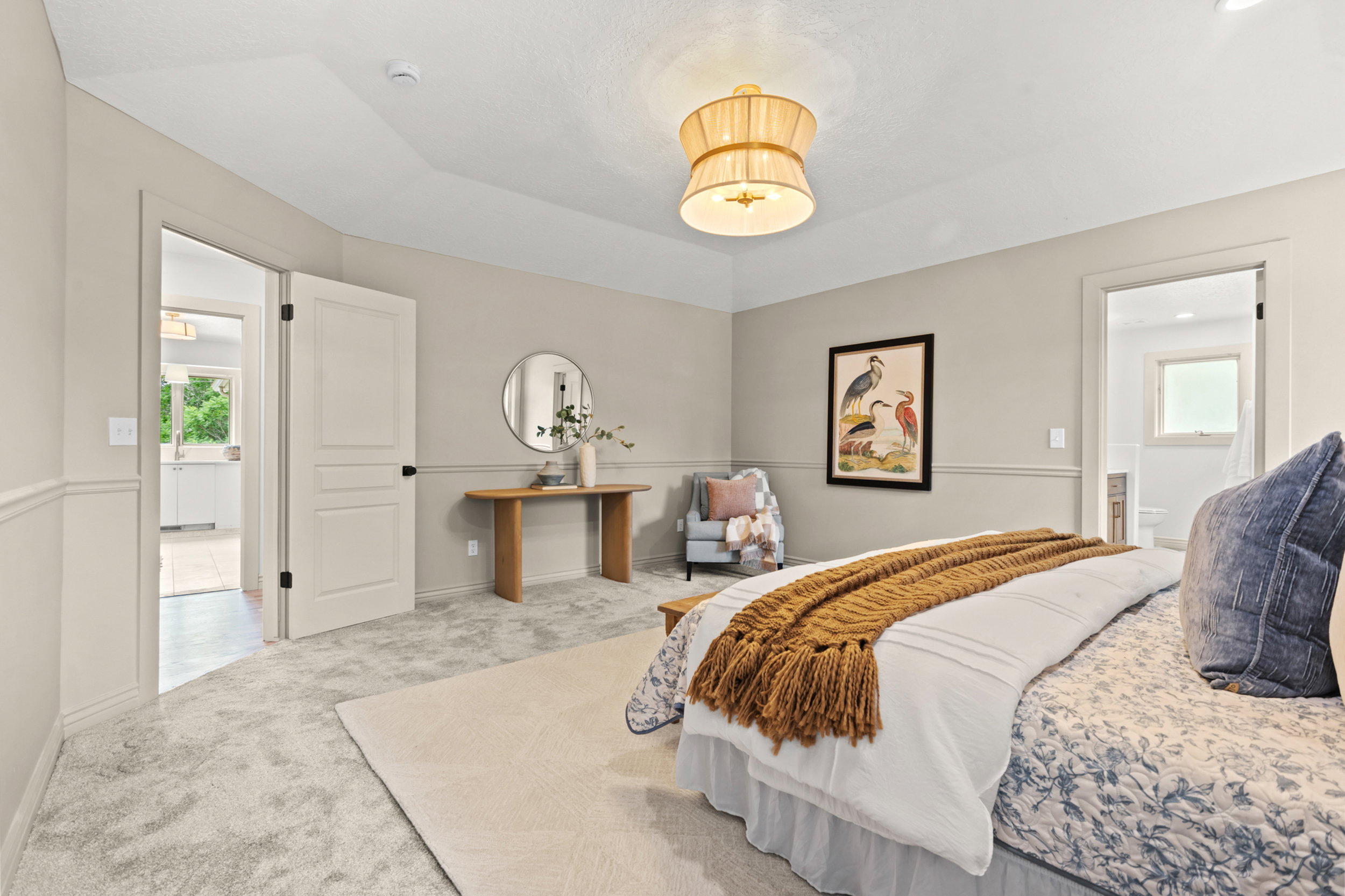 Light gray wall-to-wall carpeting complements neutral wall tones with wainscoting details