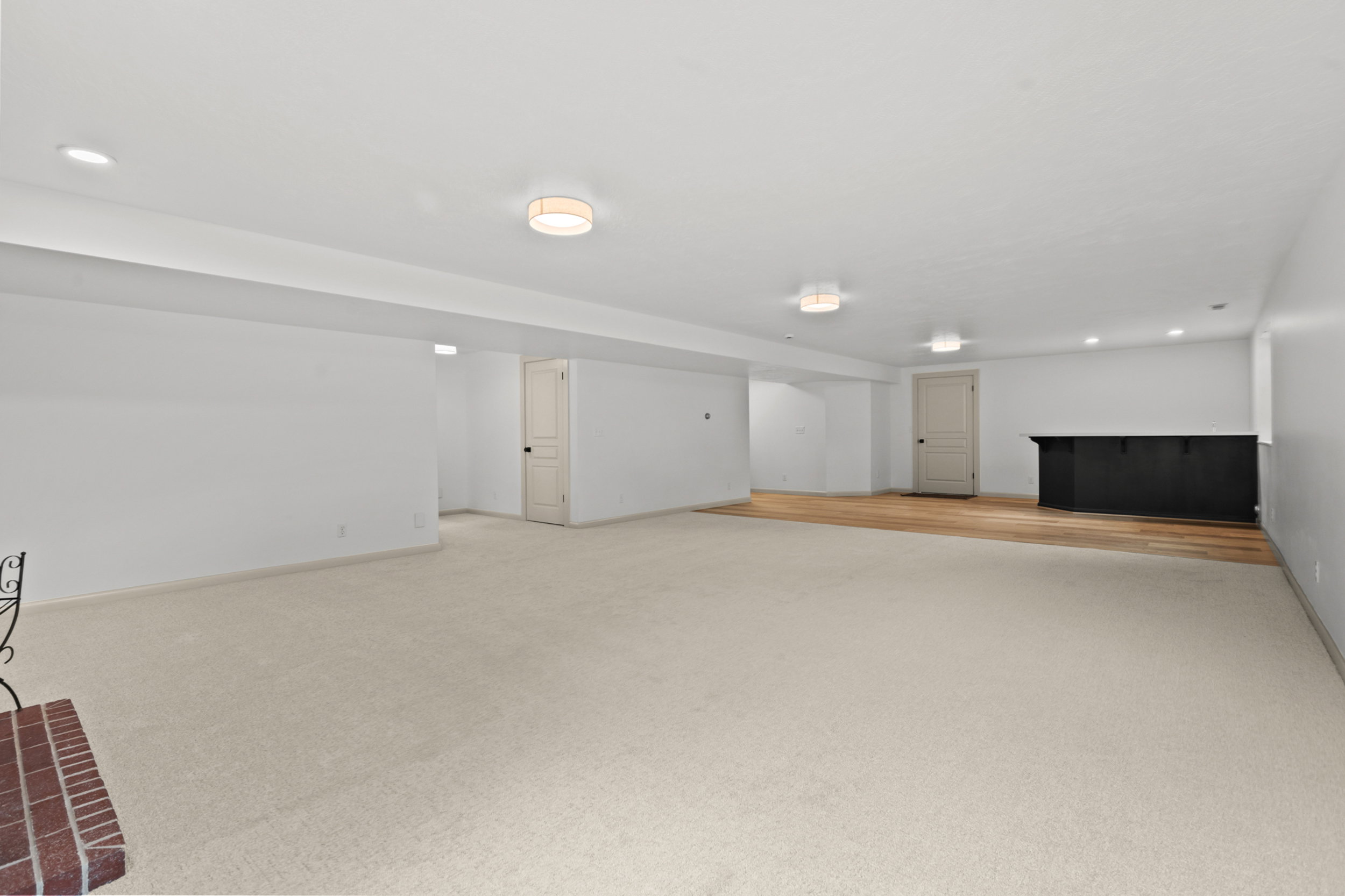 Spacious lower-level area with recessed lighting and flush-mount fixtures