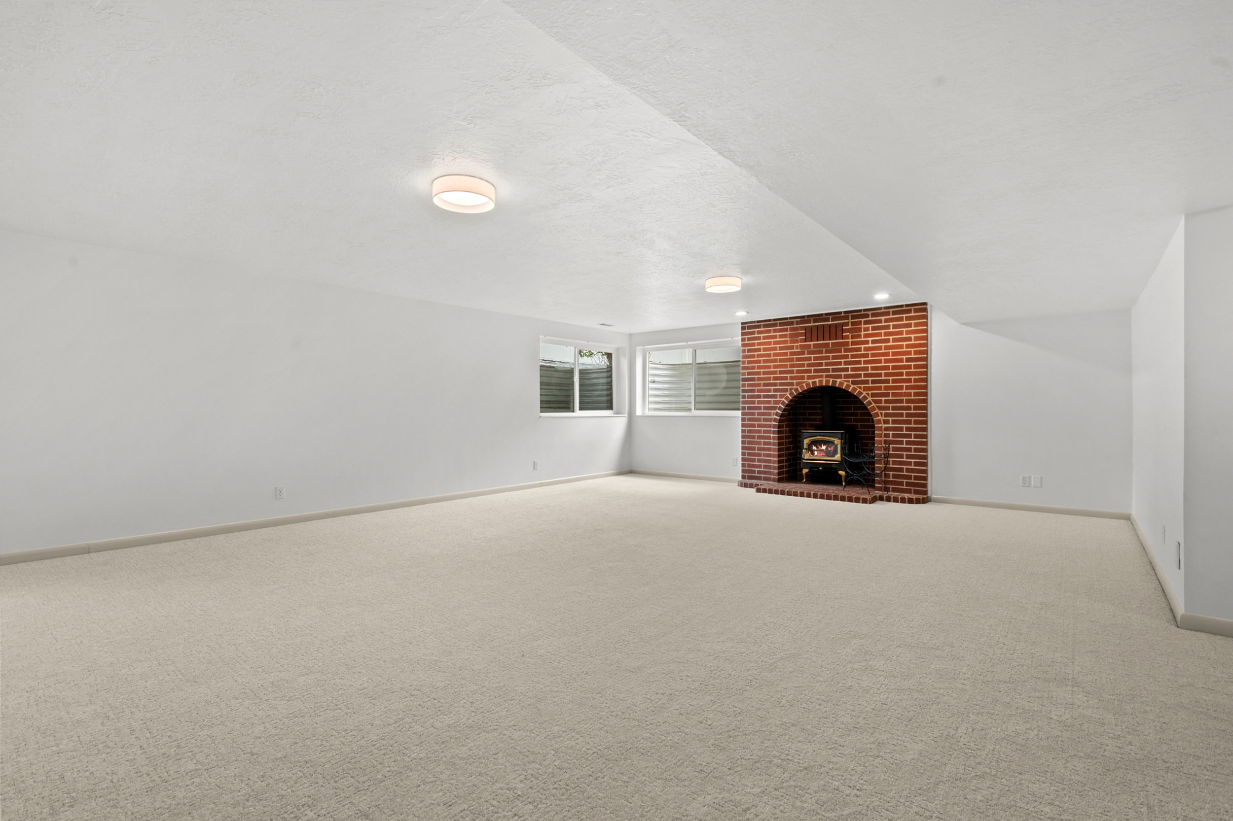 Spacious room featuring light-toned carpeting and white painted walls