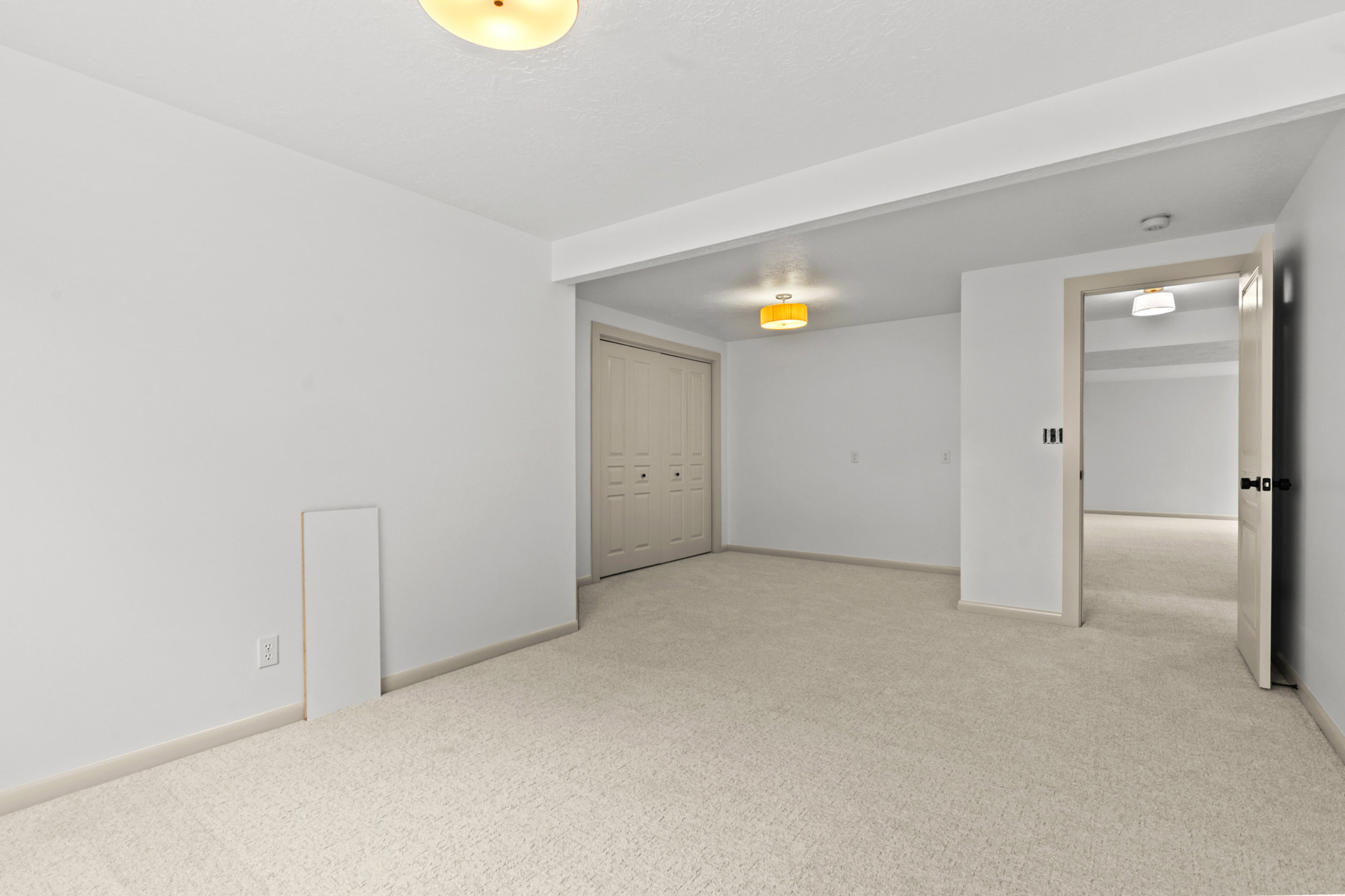 Spacious room with plush carpeting, neutral wall finishes, and a flush-mount ceiling light