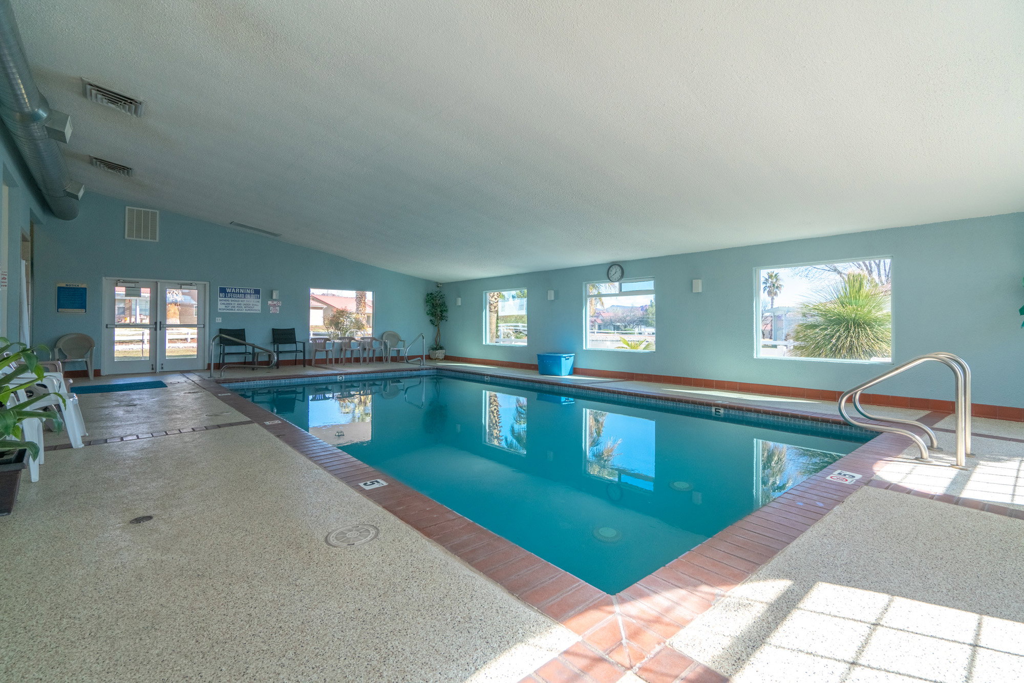 Indoor swimming pool with a textured deck surround and brick coping