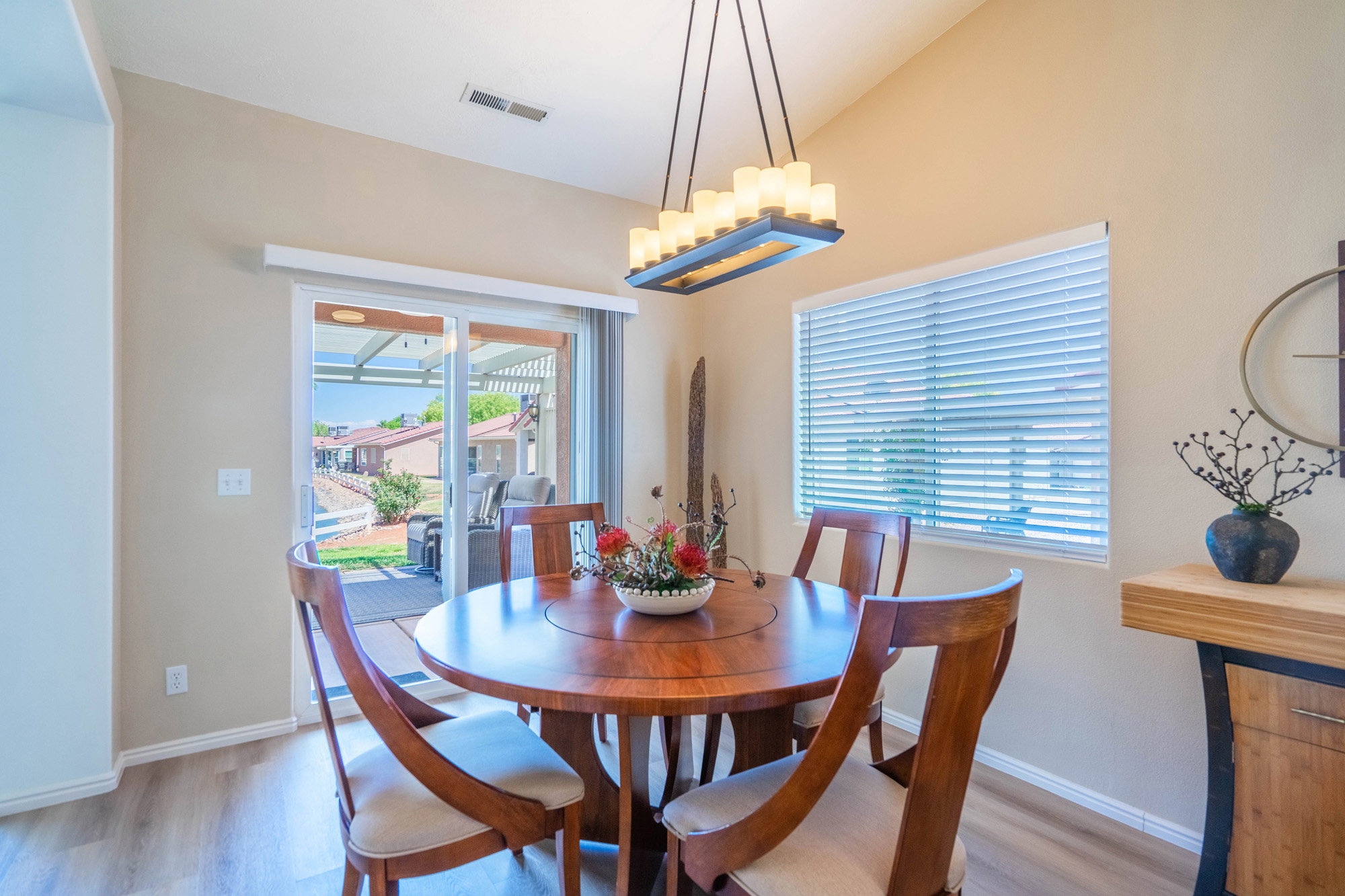 Dining area with wood-finish flooring and a rectangular chandelier