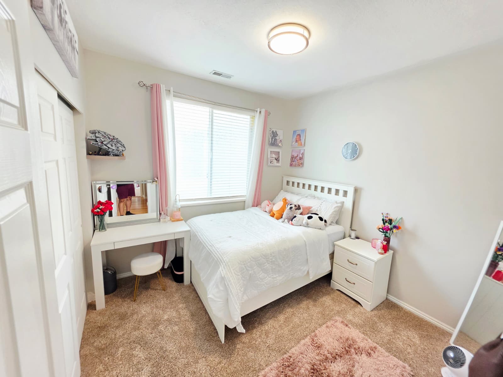 Carpeted bedroom featuring a window with blinds, white paneled closet doors, a built-in flush mount ceiling light, and light-colored walls